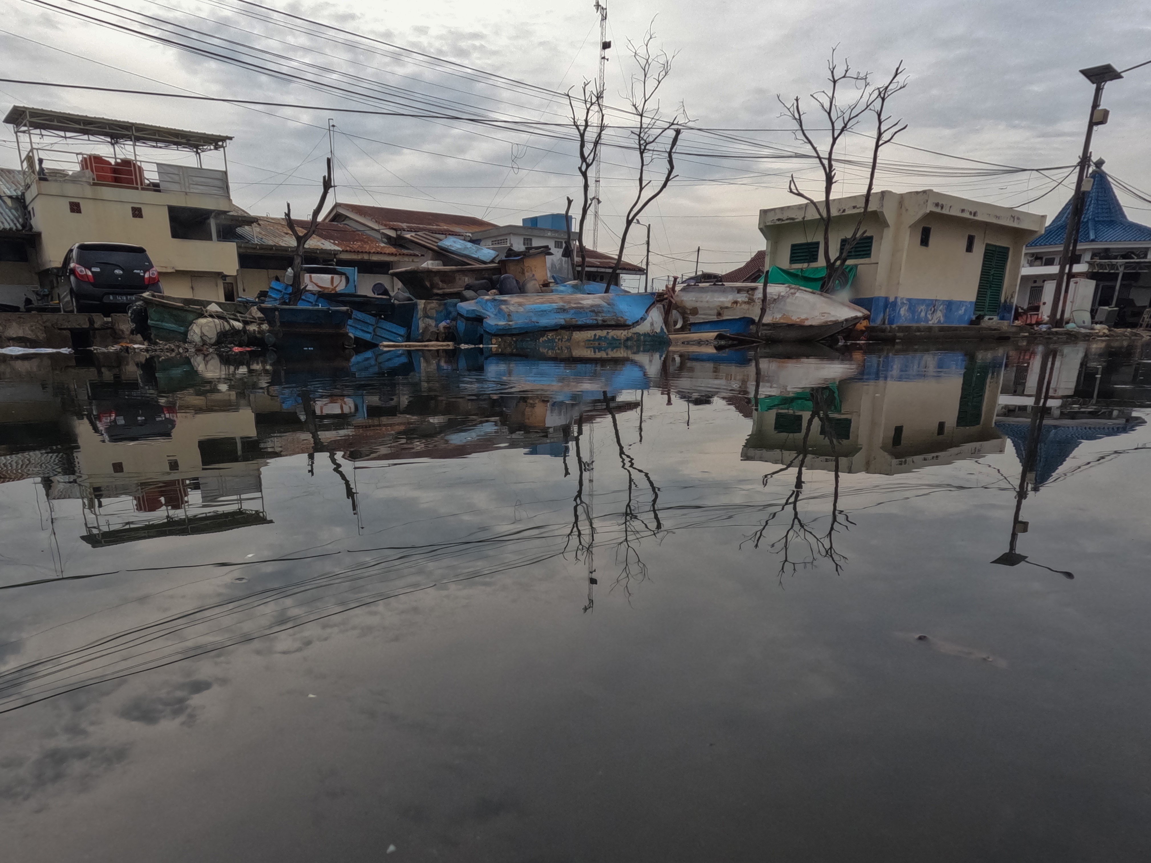 Suasana jalan yang terendam limpasan air laut ke daratan atau rob di Pelabuhan Muara Baru Jakarta, Rabu (28/12/2022).