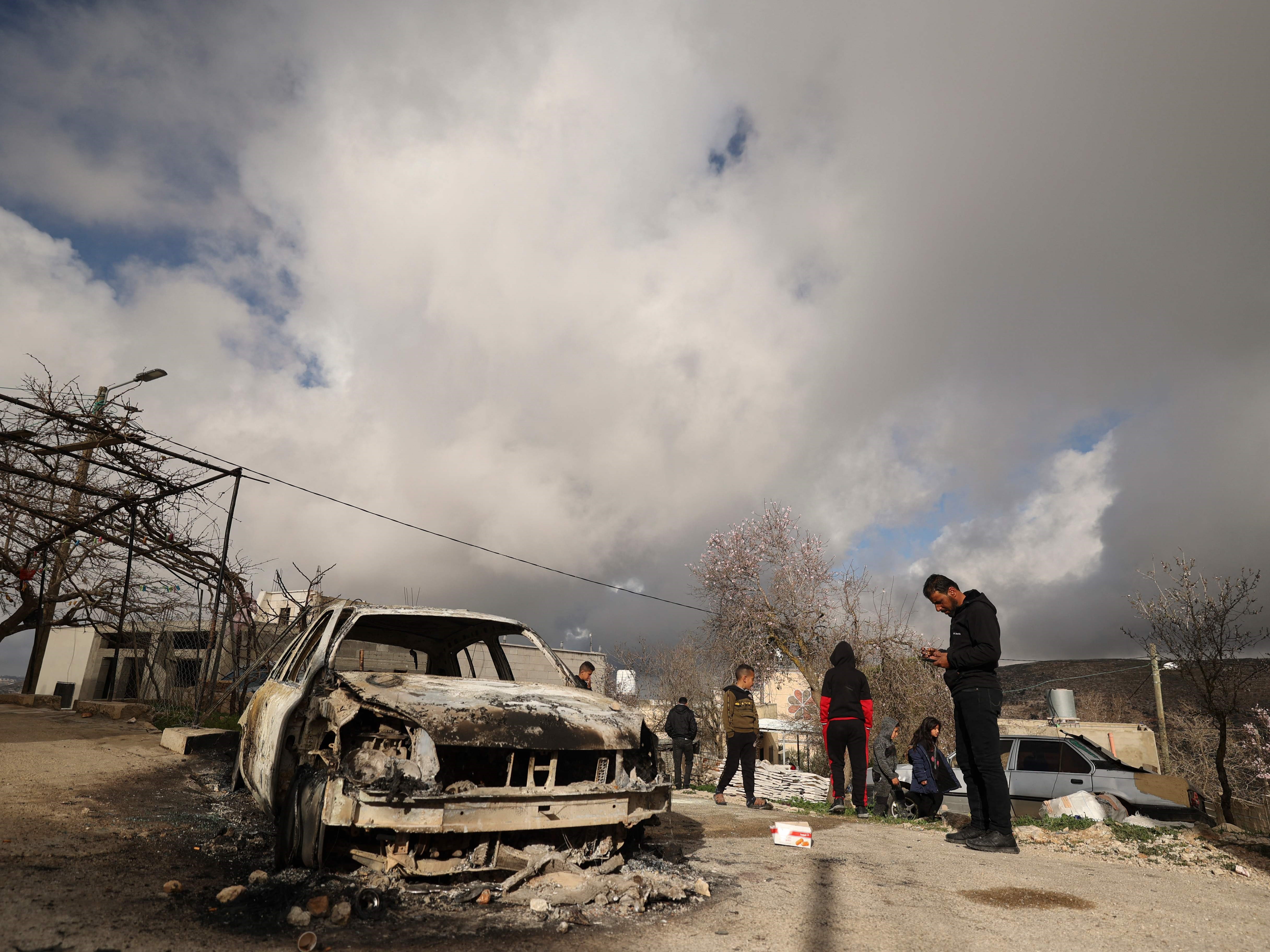Warga Palestina memeriksa mobil yang hangus setelah diduga dibakar pemukim Israel di desa Jalud, selatan Nablus, Tepi Barat yang diduduki.