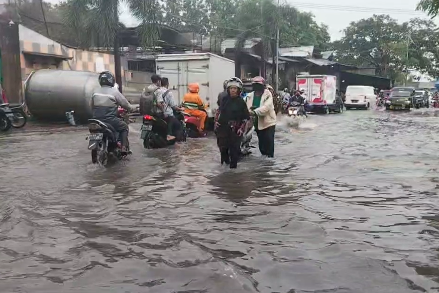 Banjir merendam Jalan Tanjungsari Surabaya.