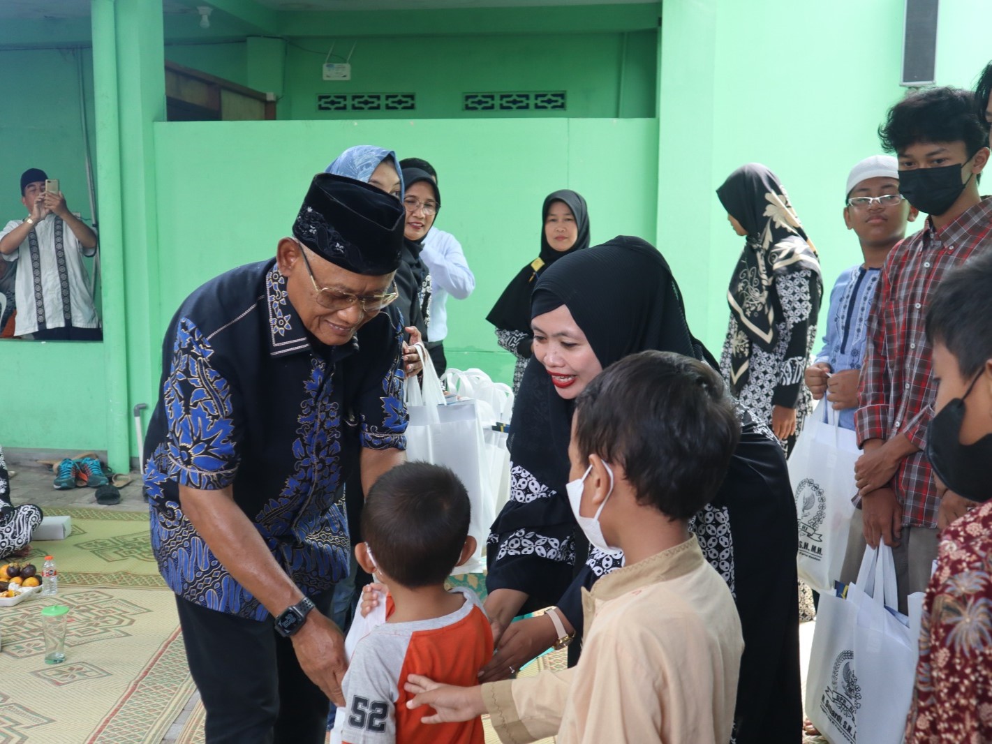 Legislator NasDem Subardi (berpeci) yang turut didampingi putri sulungnya, Anita Kurniawati, menyalami satu per satu anak-anak yatim.