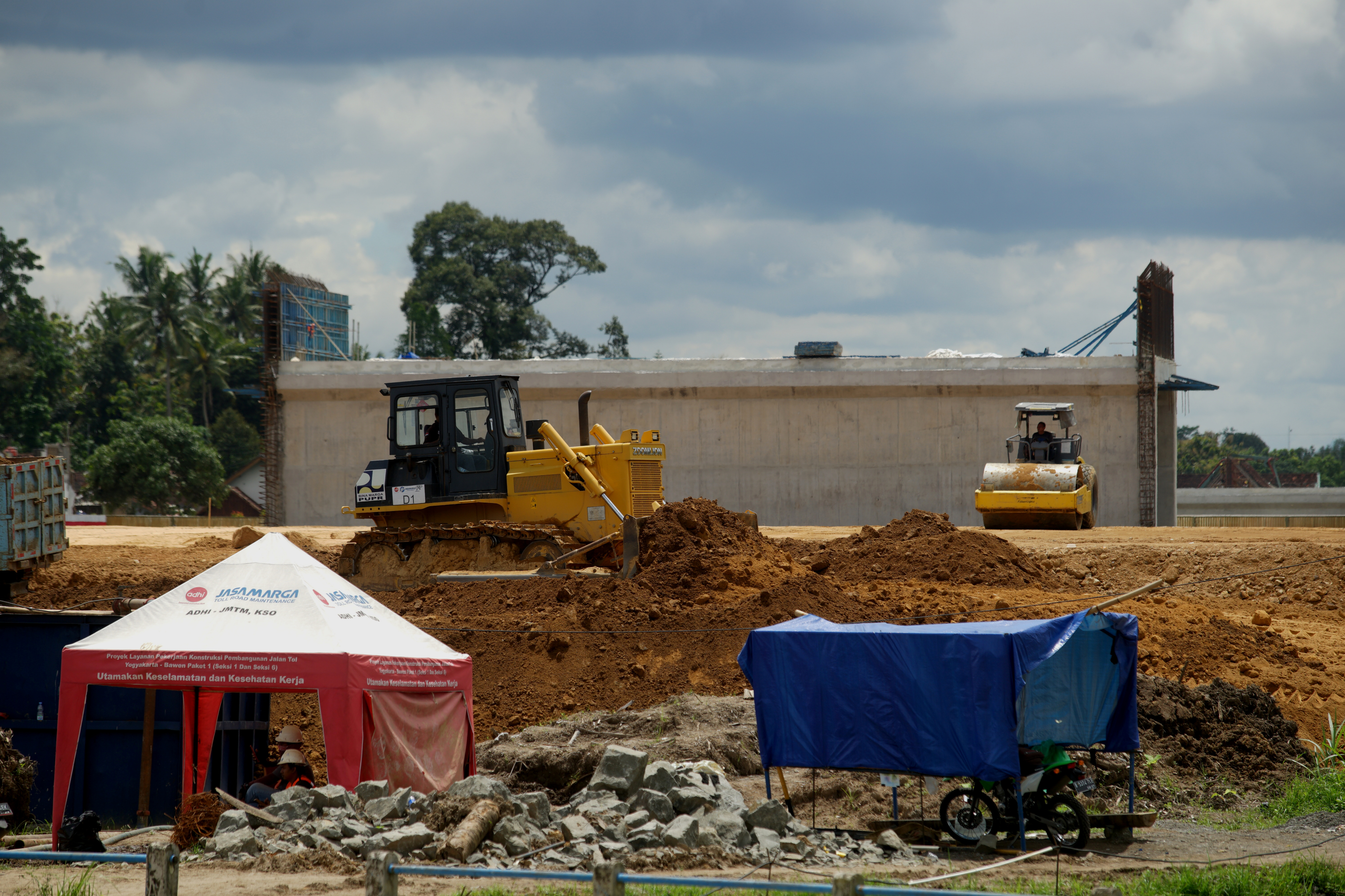 Pekerja melakukan pengerjaan konstruksi Jalan Tol Yogyakarta-Bawen Seksi 1 menggunakan alat berat di Tirtoadi, Mlati, Sleman, D.I Yogyakarta