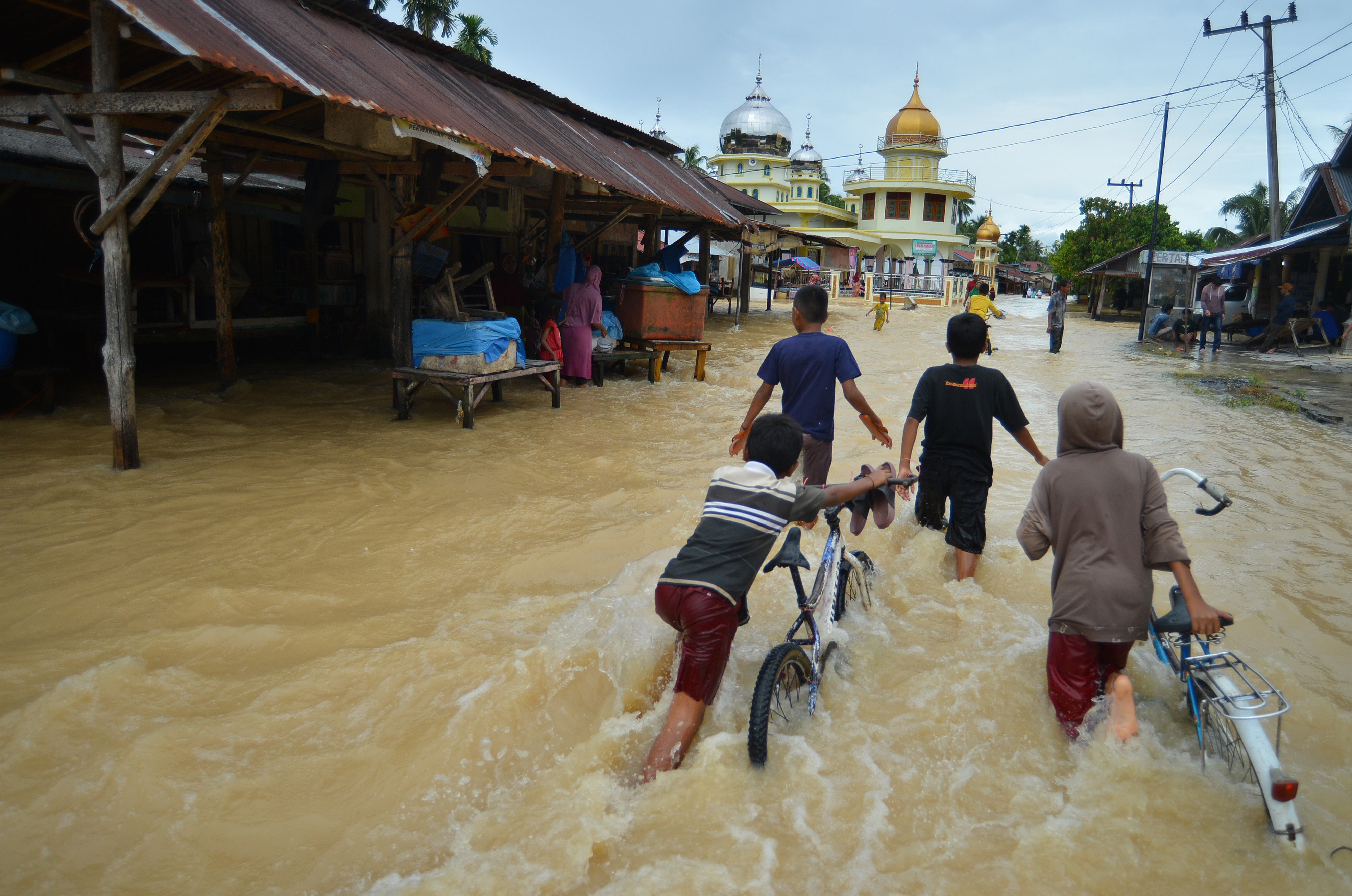 Warga melintasi banjir di Korong Kasai, Nagari Tapakis, Kabupaten Padang Pariaman, Sumatera Barat, Selasa (24/1/2023).