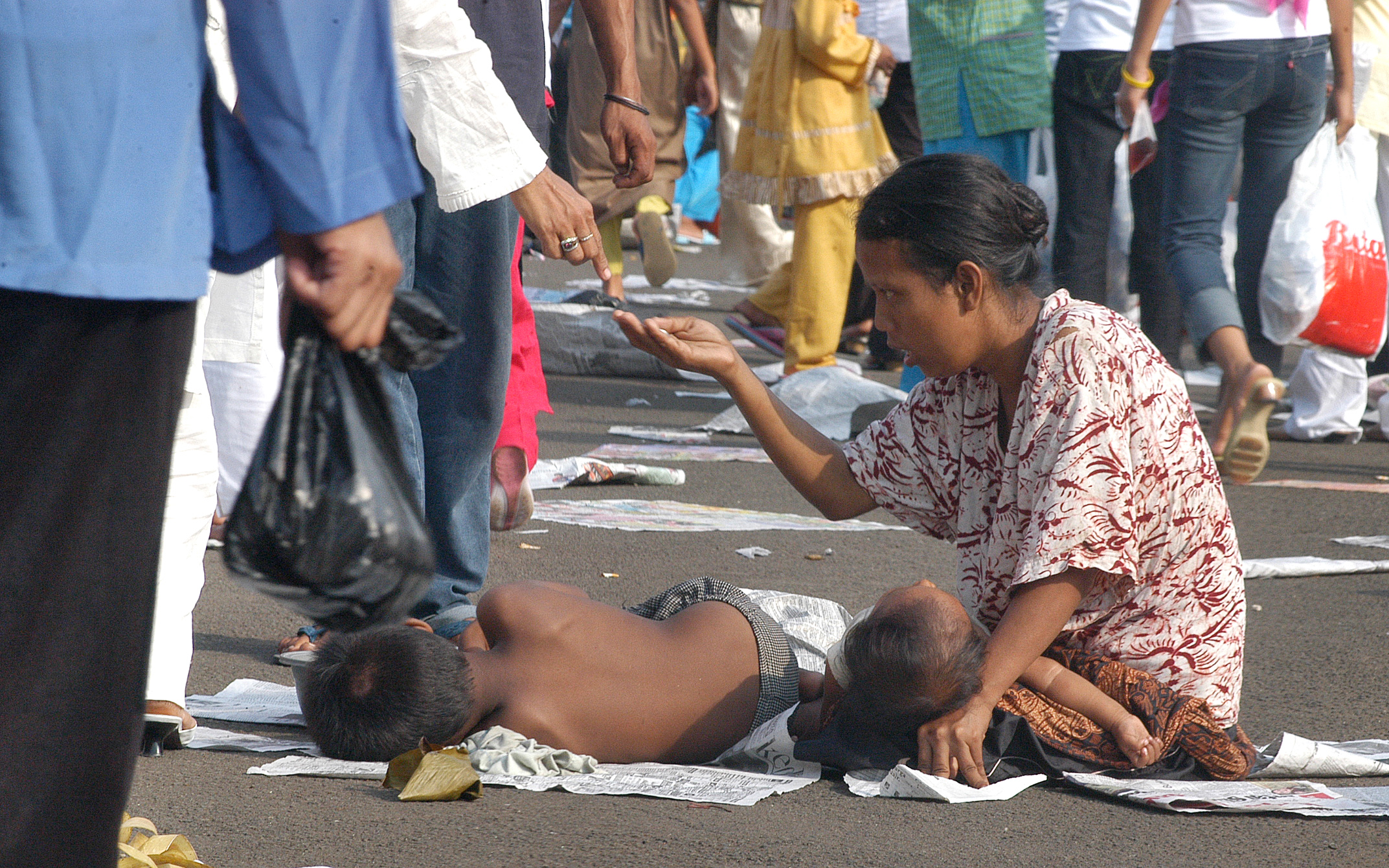 Seorang pengemis dengan dua anaknya megemis ditrotoar kali disekitar Masjid Istiqlal Jakarta