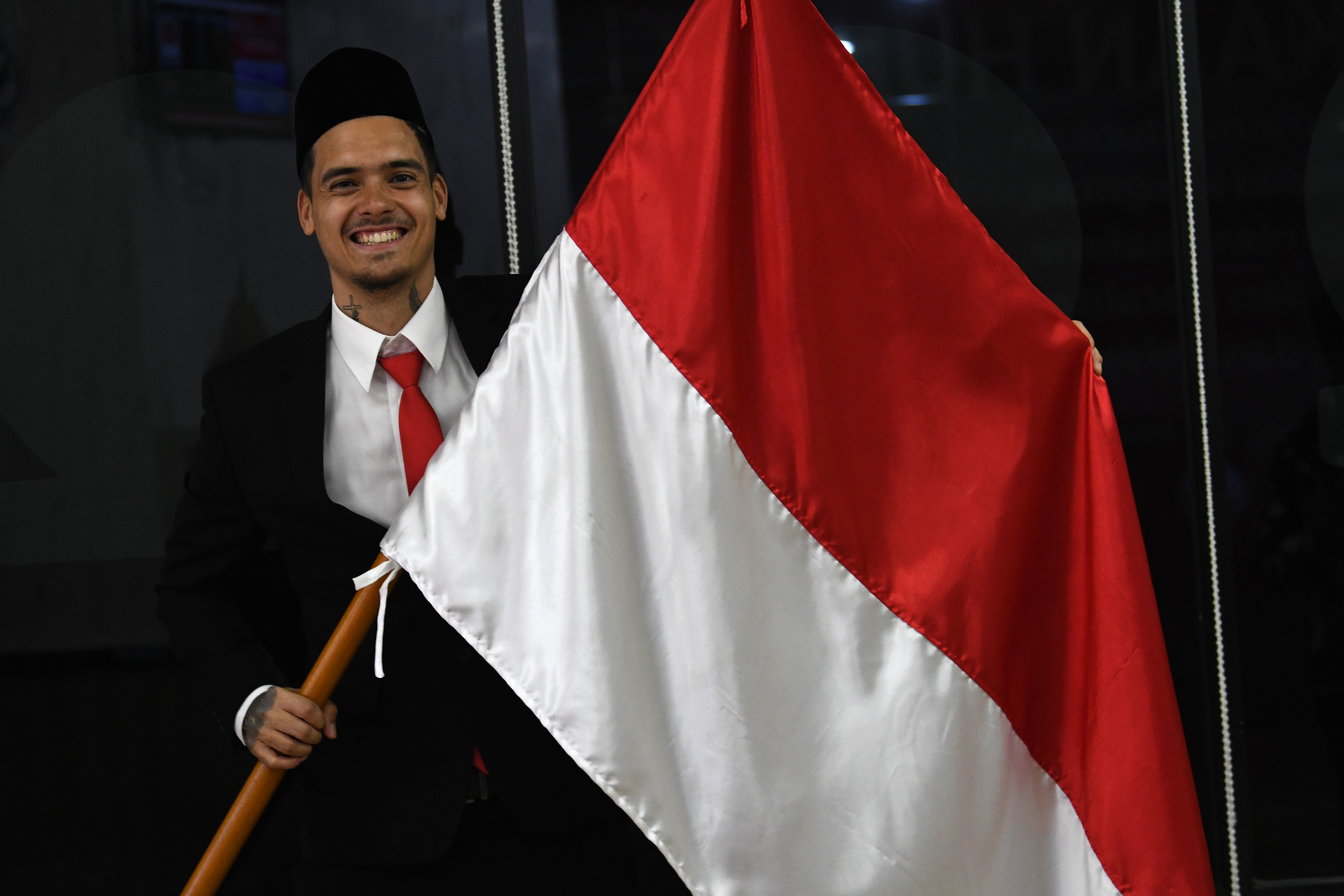 Pesepak bola Shayne Pattynama berpose dengan bendera Merah Putih usai pembacaan sumpah menjadi WNI di Jakarta, Selasa (24/1).