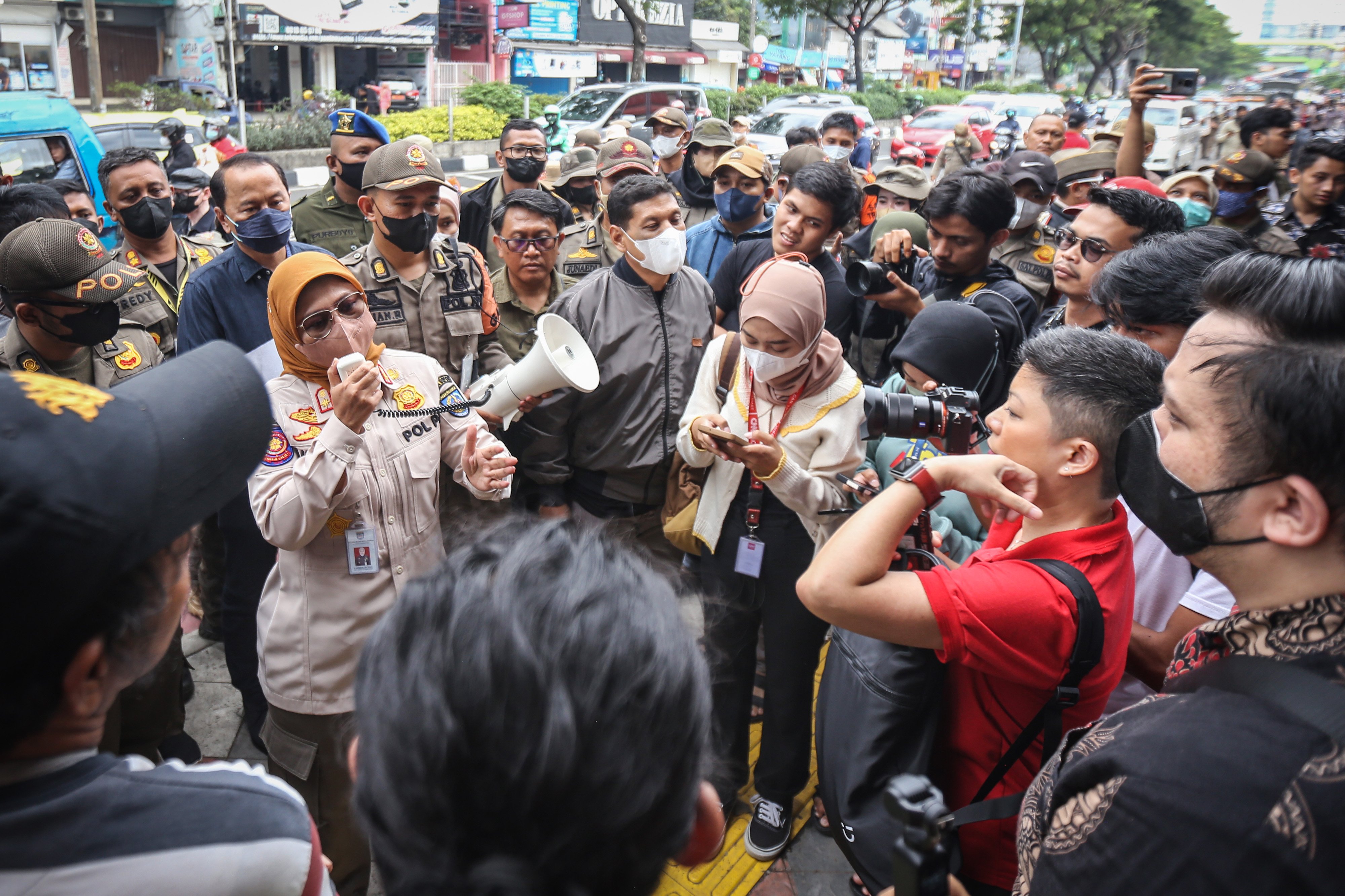 Wali murid menghadang petugas Satpol PP yang akan mengambil aset di SDN Pondok Cina 1, Depok, Jawa Barat, Minggu (11/12/2022). 