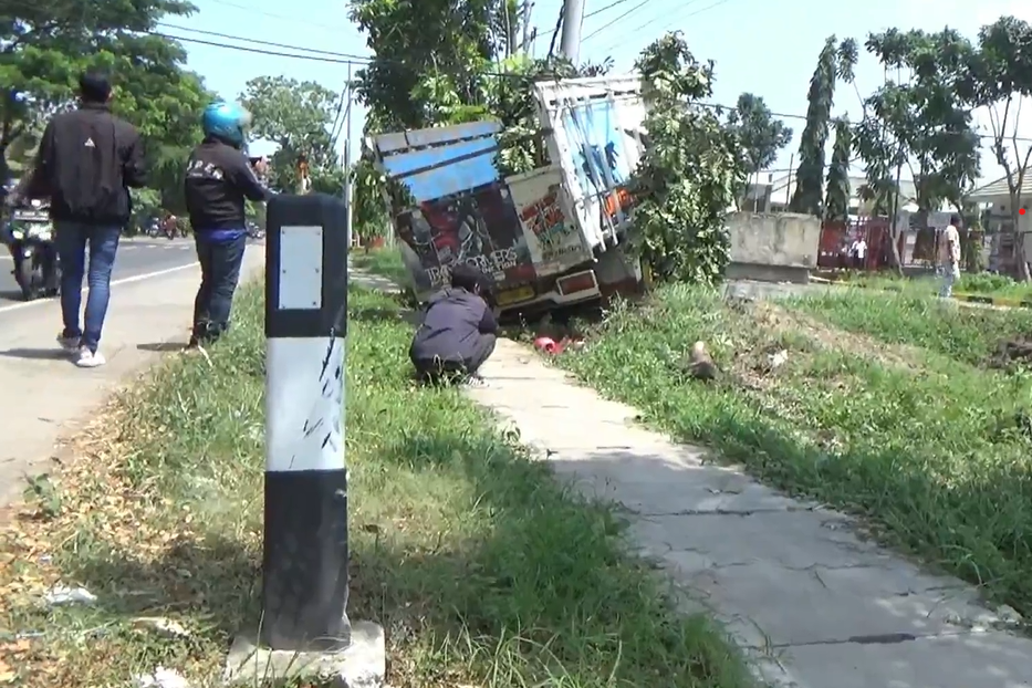 Truk yang berhenti setelah menabrak sepeda motor. 
