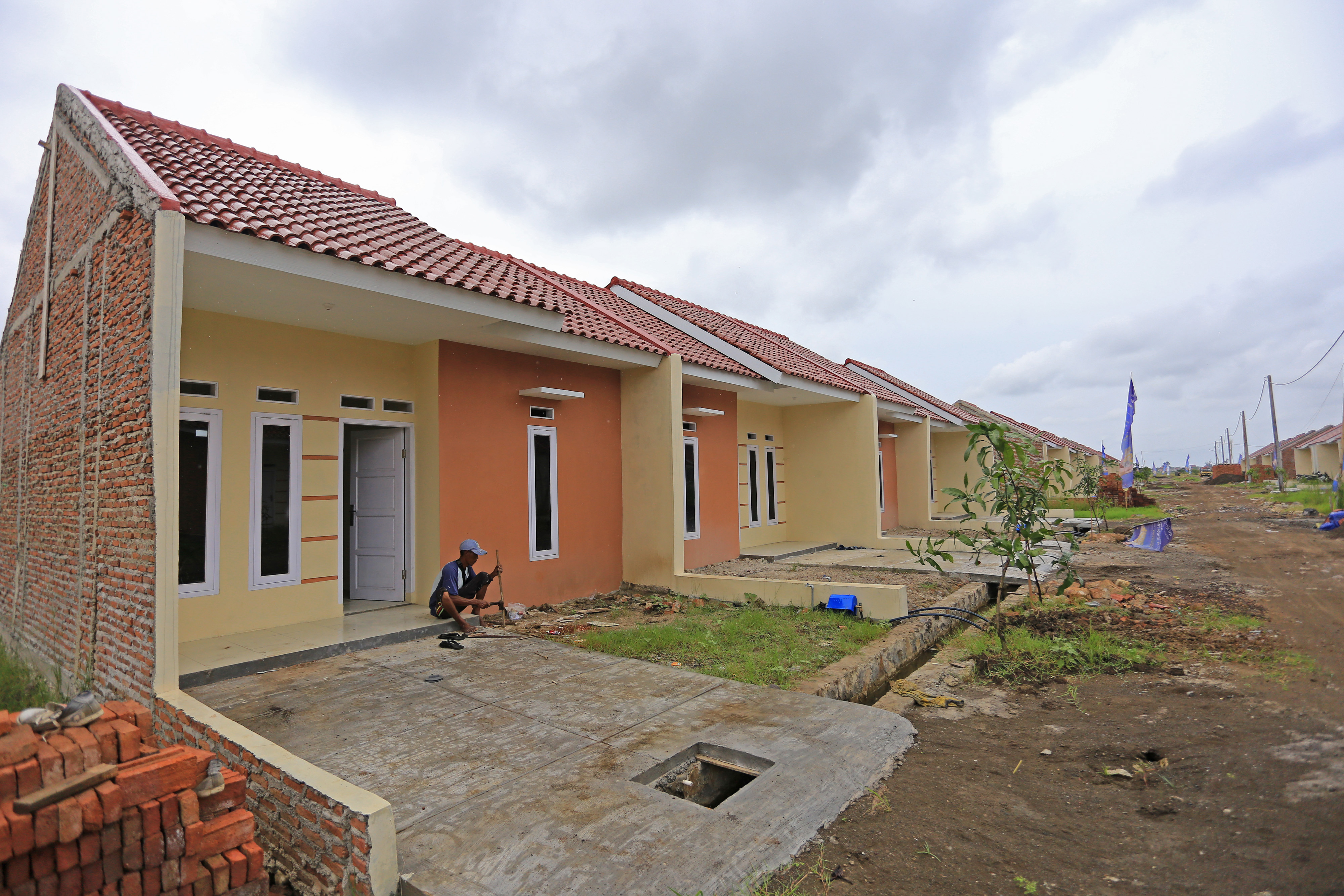 Pekerja menyelesaikan pembangunan perumahan di Margadadi, Indramayu, Jawa Barat.
