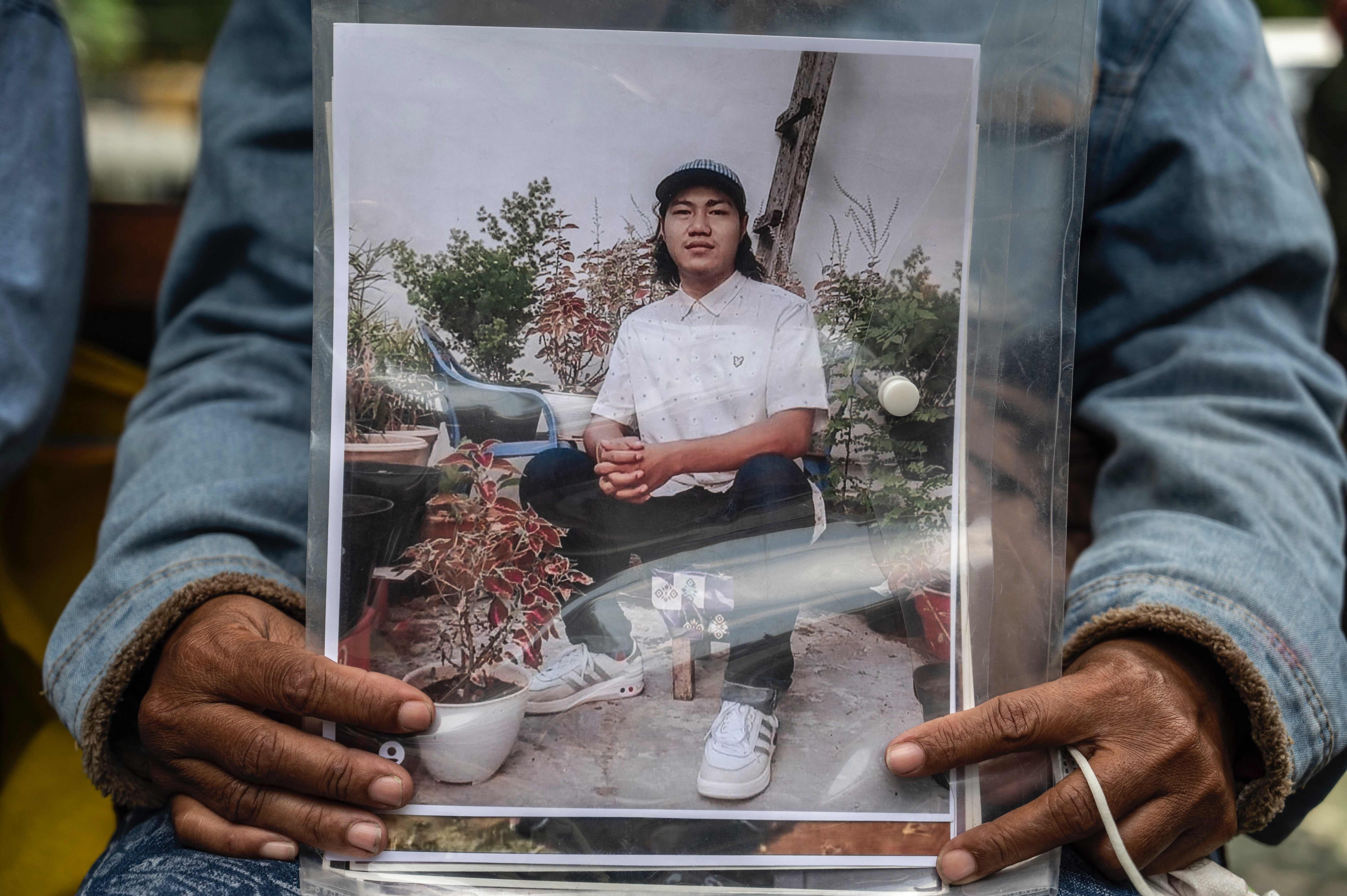 Rini Hanifah memegang foto anaknya Agus Riansyah yang menjadi satu dari 135 korban meninggal dalam Tragedi Kanjuruhan di PN Surabaya.