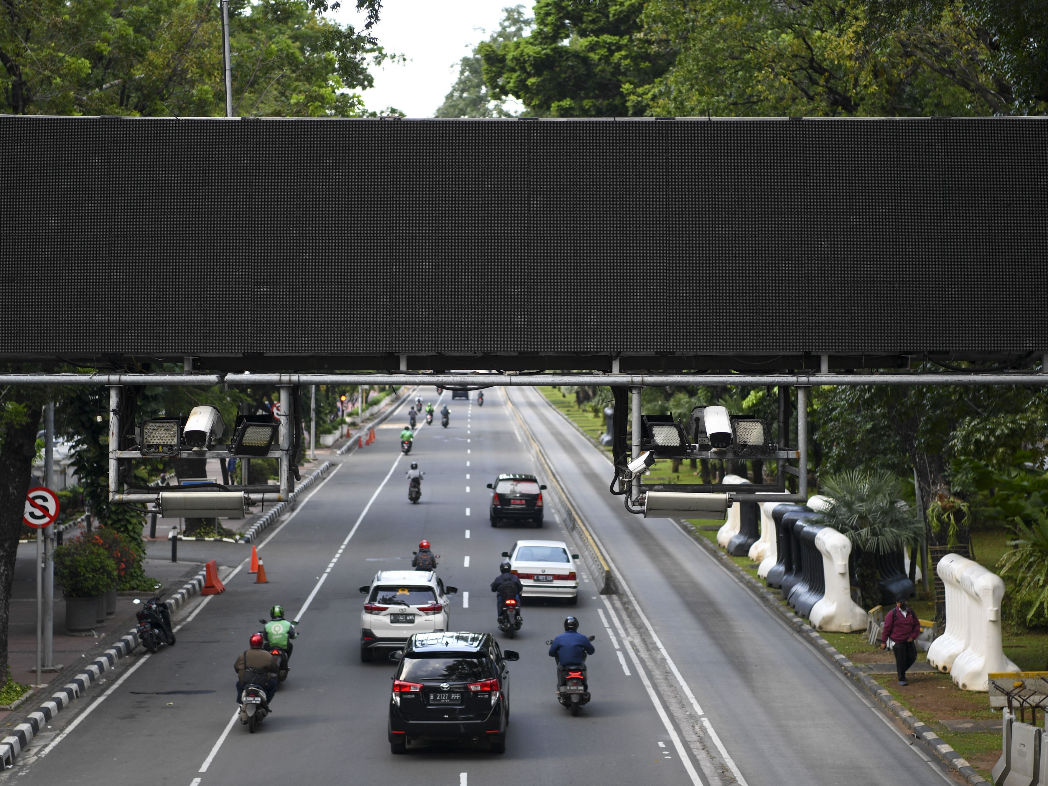 Sejumlah kendaraan bermotor melintas di bawah Alat Sistem Jalan Berbayar Elektronik (ERP) di Jalan Medan Merdeka Barat, Jakarta.
