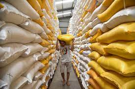 Pekerja mengangkut karung berisi beras di gudang Bulog.