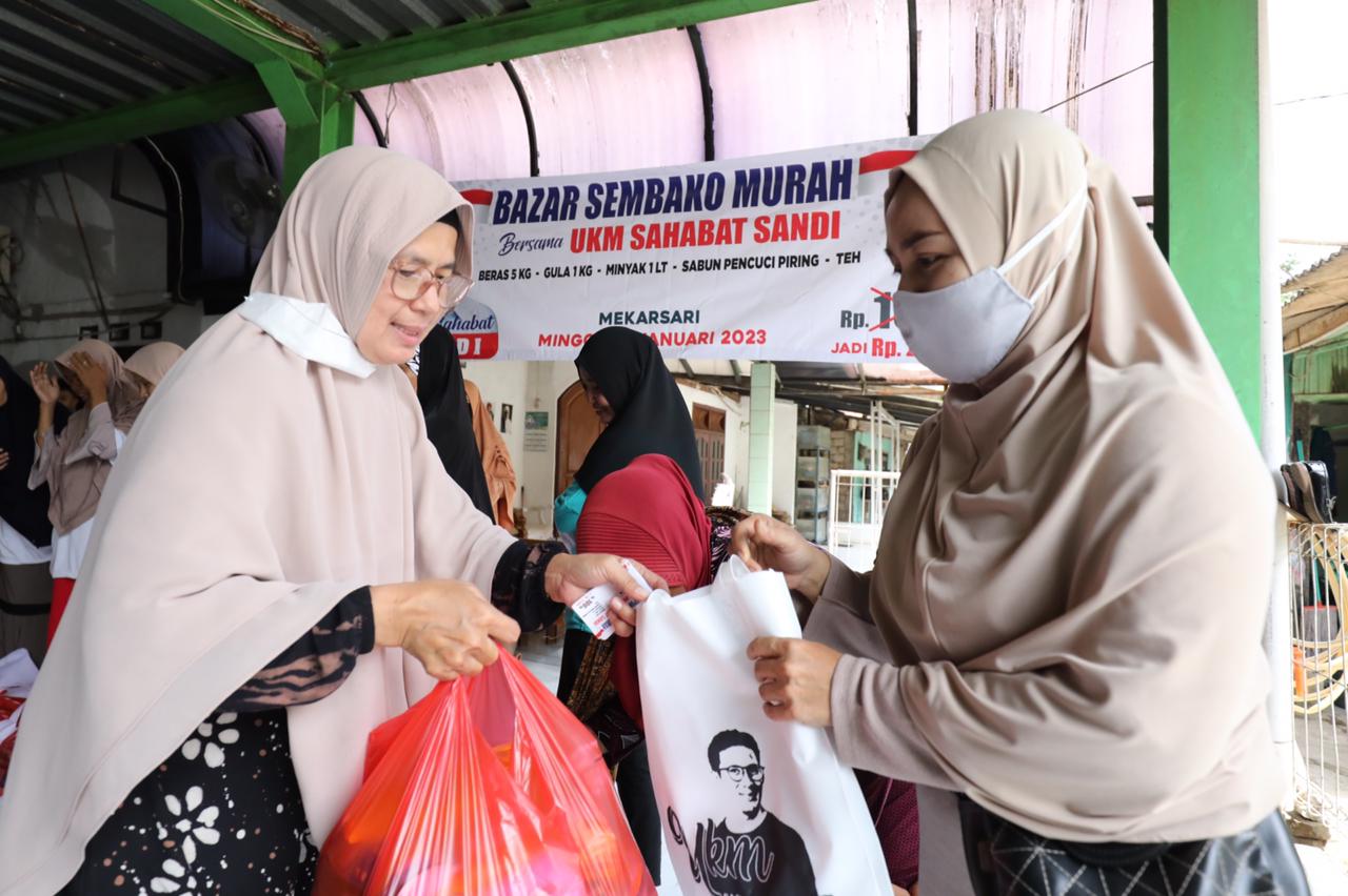 Kalangan ibu-ibu mengantre membeli paket sembako di bazar murah yang dihela UKM Sahabat Sandiuno di Desa Mekarsari, Cileungsi, Kabupaten Bog