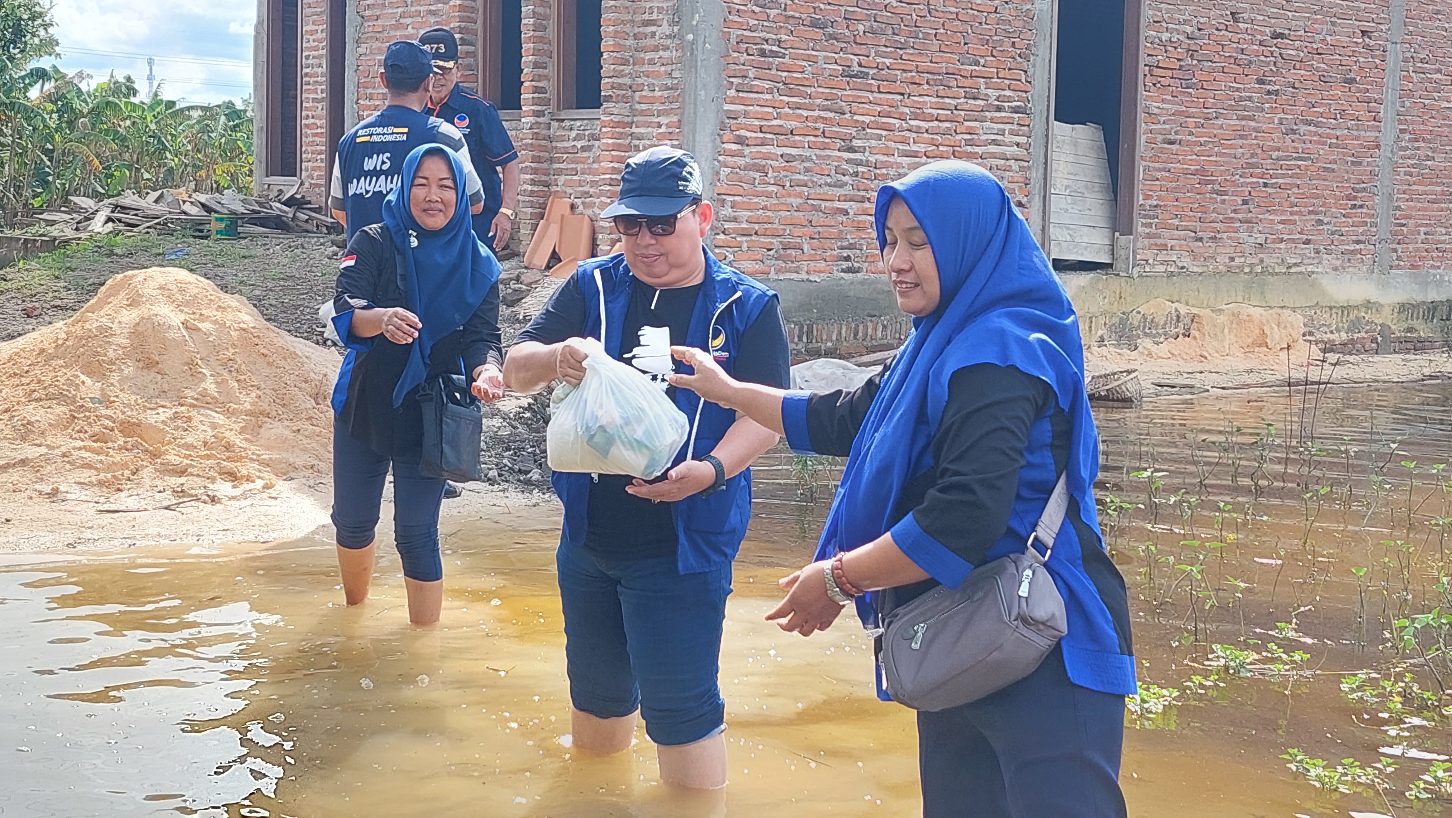 Sejumlah kader NasDem Kudus, Jawa Tengah, menyerahkan bantuan sembako ke rumah warga yang terdampak banjir