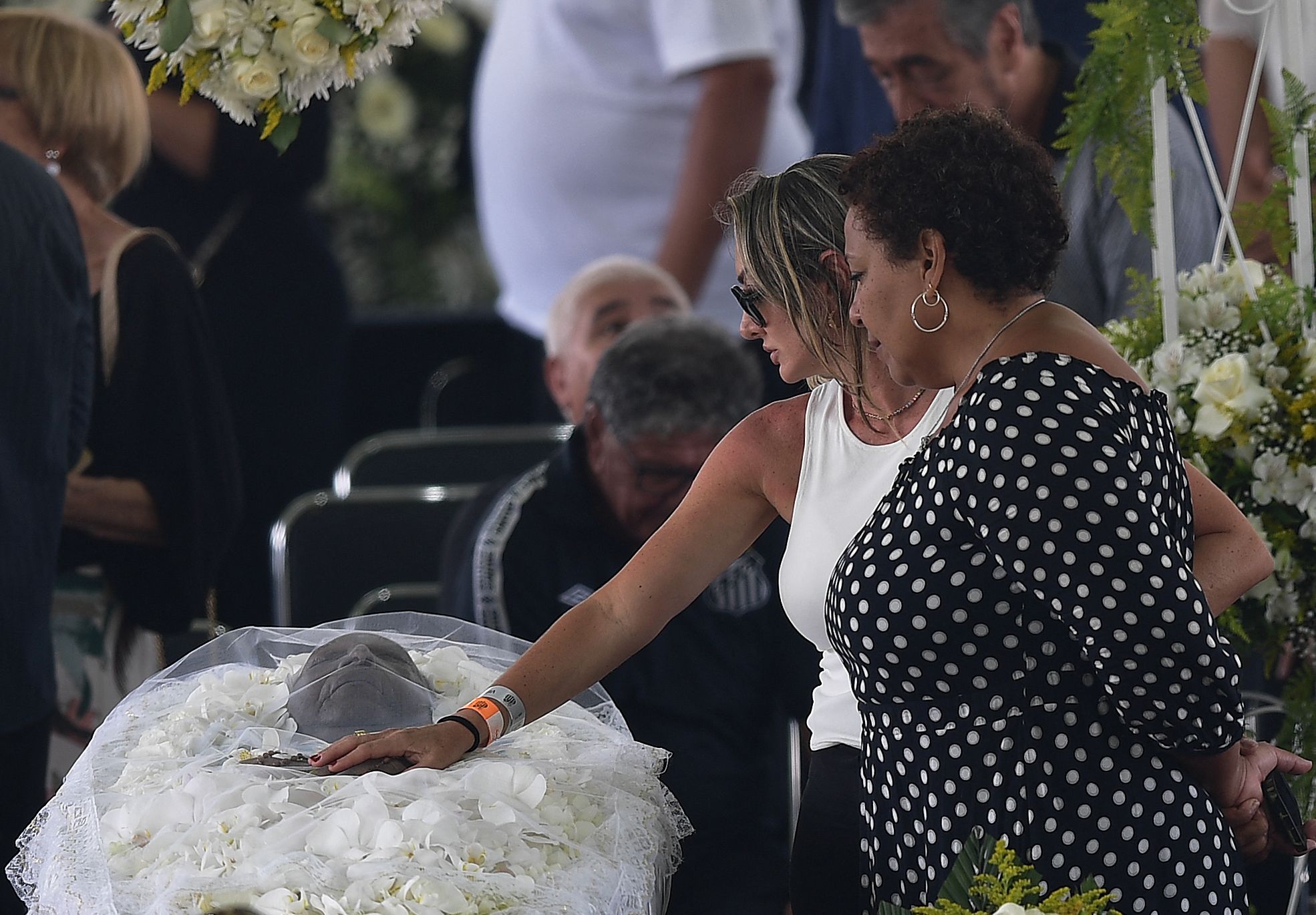 Putri Pele, Kelly Cristina (kanan), berdiri di samping peti jenazah sang ayah di Stadion Urbano Caldeira, Santos, Sao Paulo, Senin (2/1).