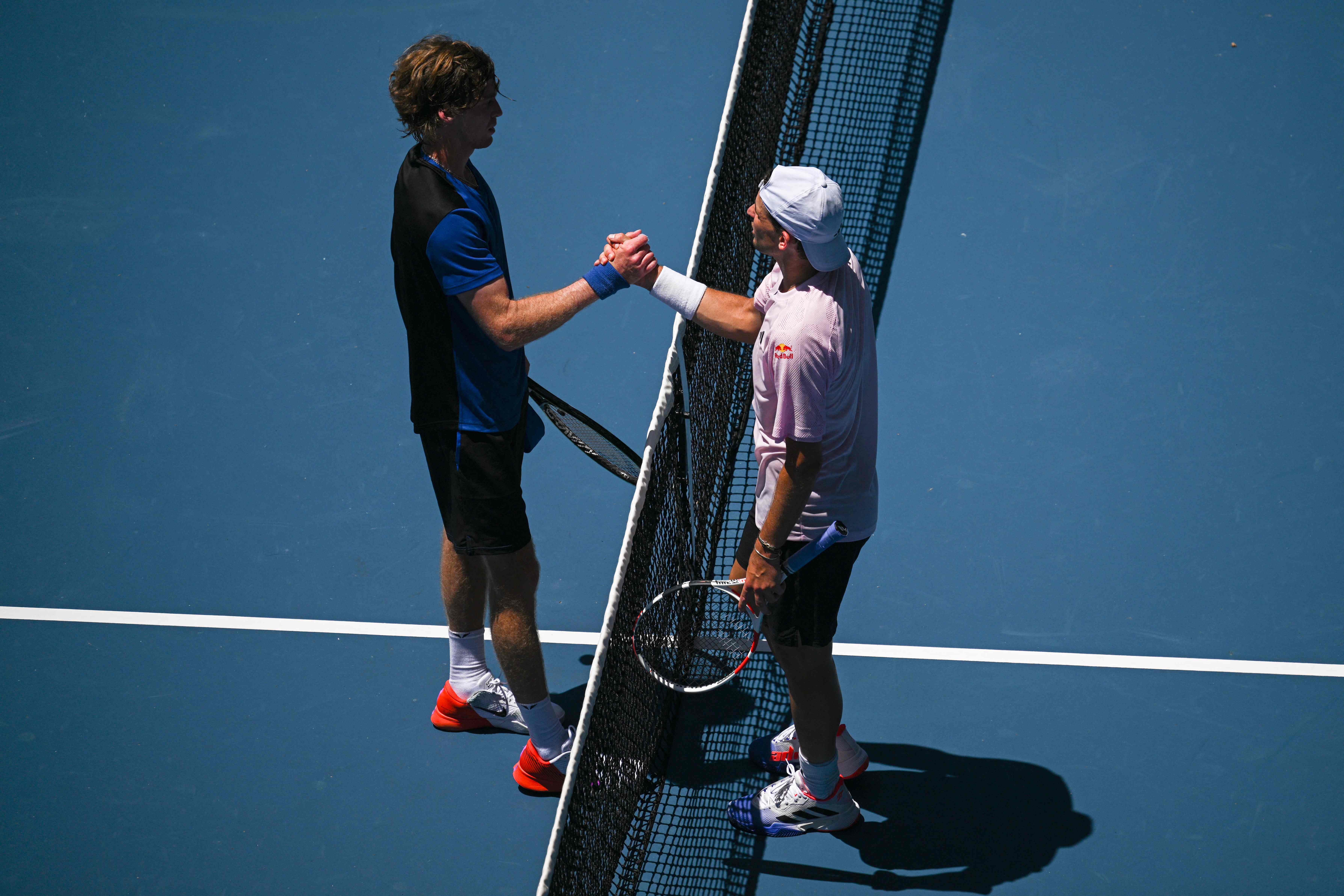 Usai menang pertandingan di Australia Terbuka 2023, petenis Rusia Andrey Rublev (kiri) menyalami lawannya, Dominic Thiem, dari Australia.
