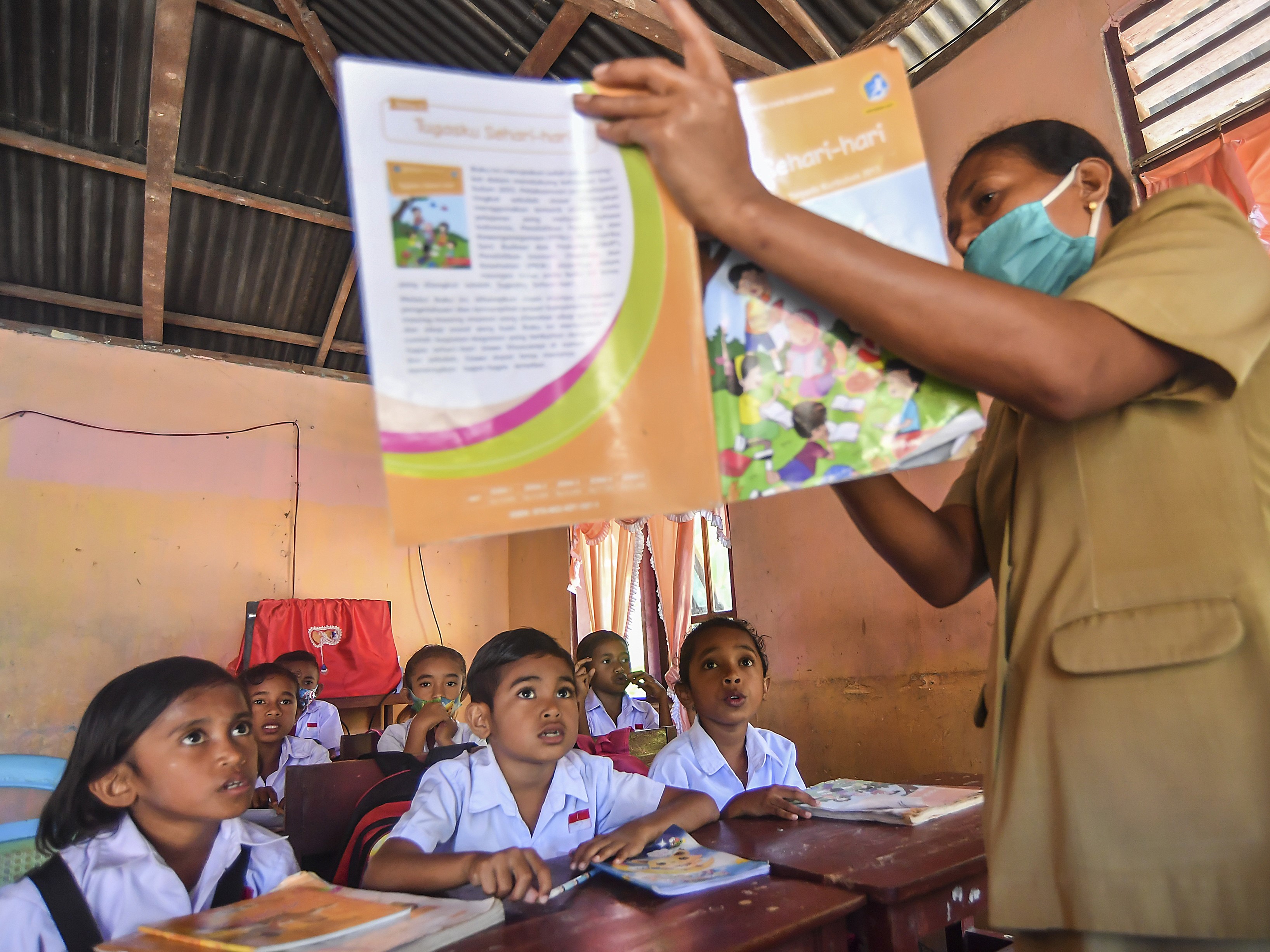 Seorang guru memberikan pelajaran saat proses belajar mengajar di salah satu rumah siswa di Desa Nuruwe, Seram Bagian Barat, Maluku.