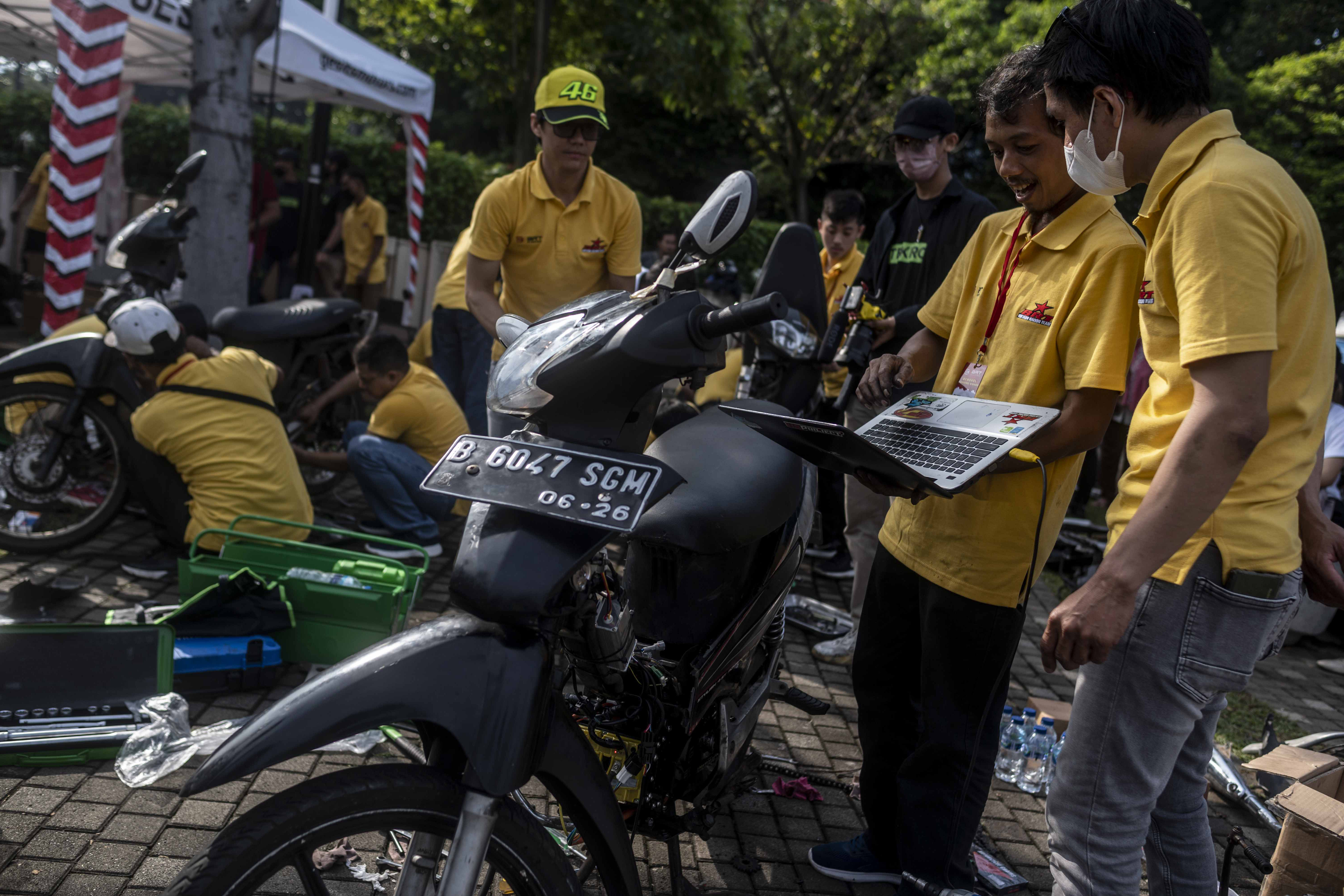 Mekanik menyelesaikan proses konversi motor listrik dalam acara Electric Vehicle (EV) FUNDAY di Plaza Timur Gelora Bung Karno, Jakarta.