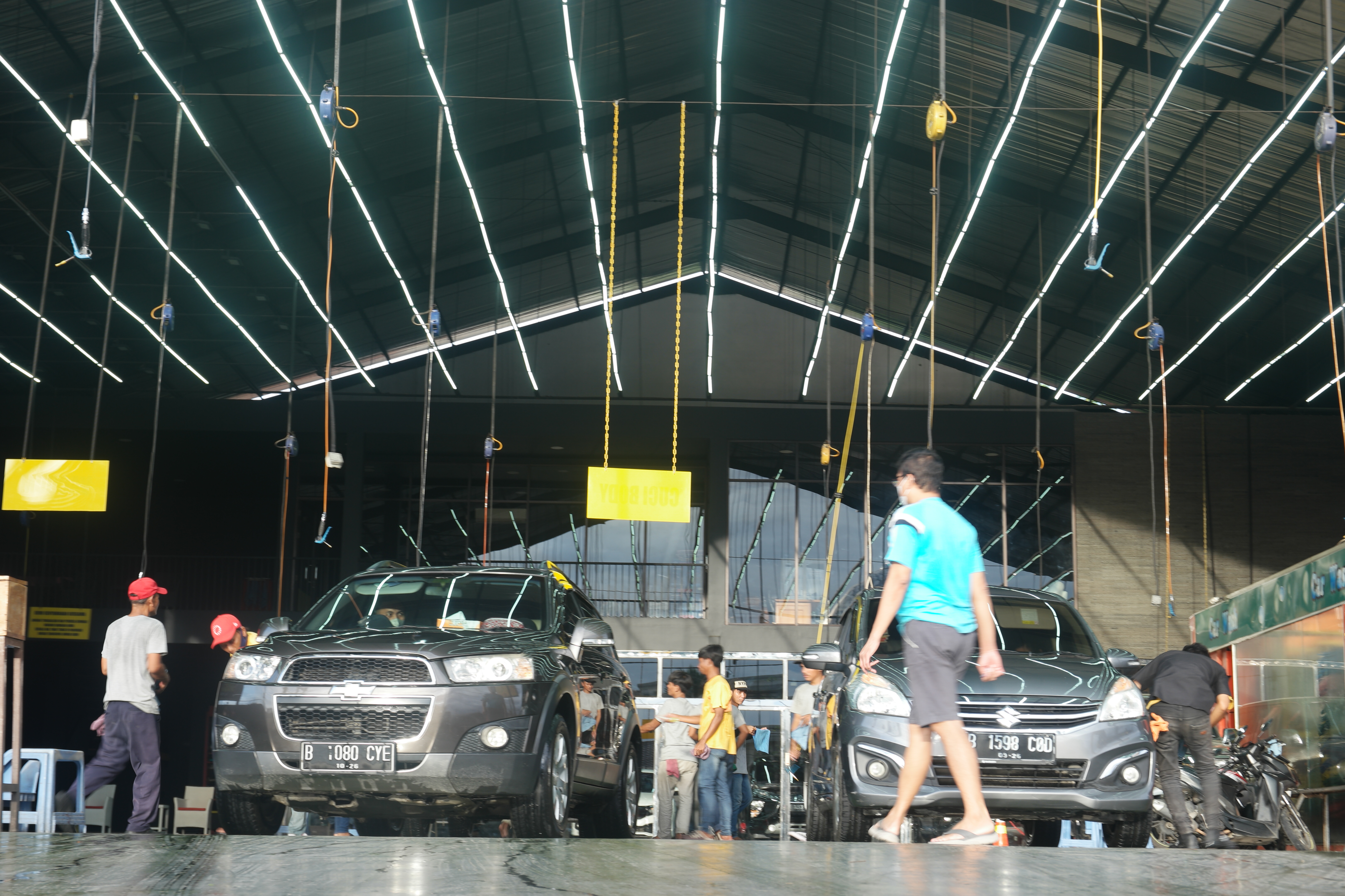  Pekerja mencuci mobil di salah satu tempat jasa pencucian mobil di Tangerang, Banten, minggu (22/1)