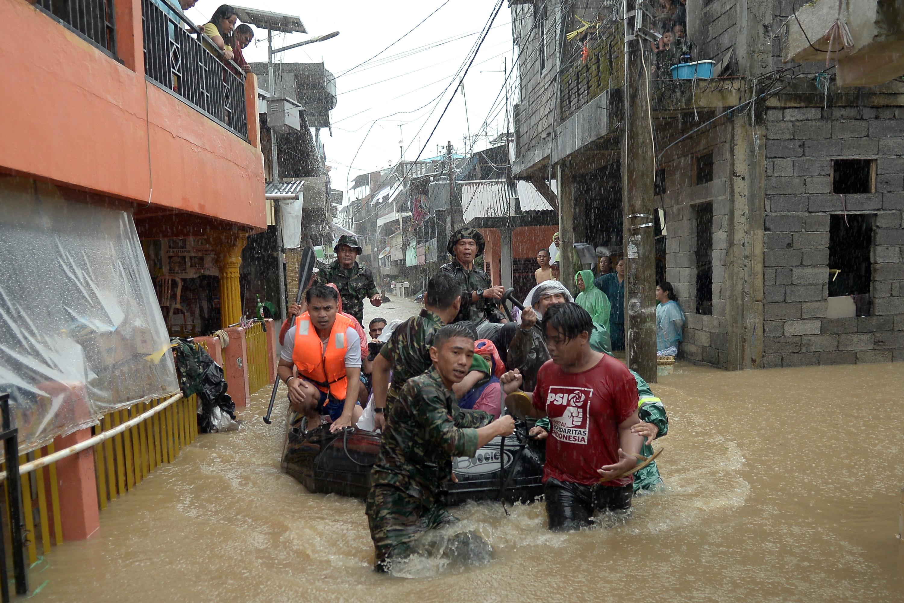 BANJIR DI MANADO: Anggota TNI mengevakuasi sejumlah warga dari rumahnya yang terendam banjir di Manado, Sulut, Jumat (27/1)