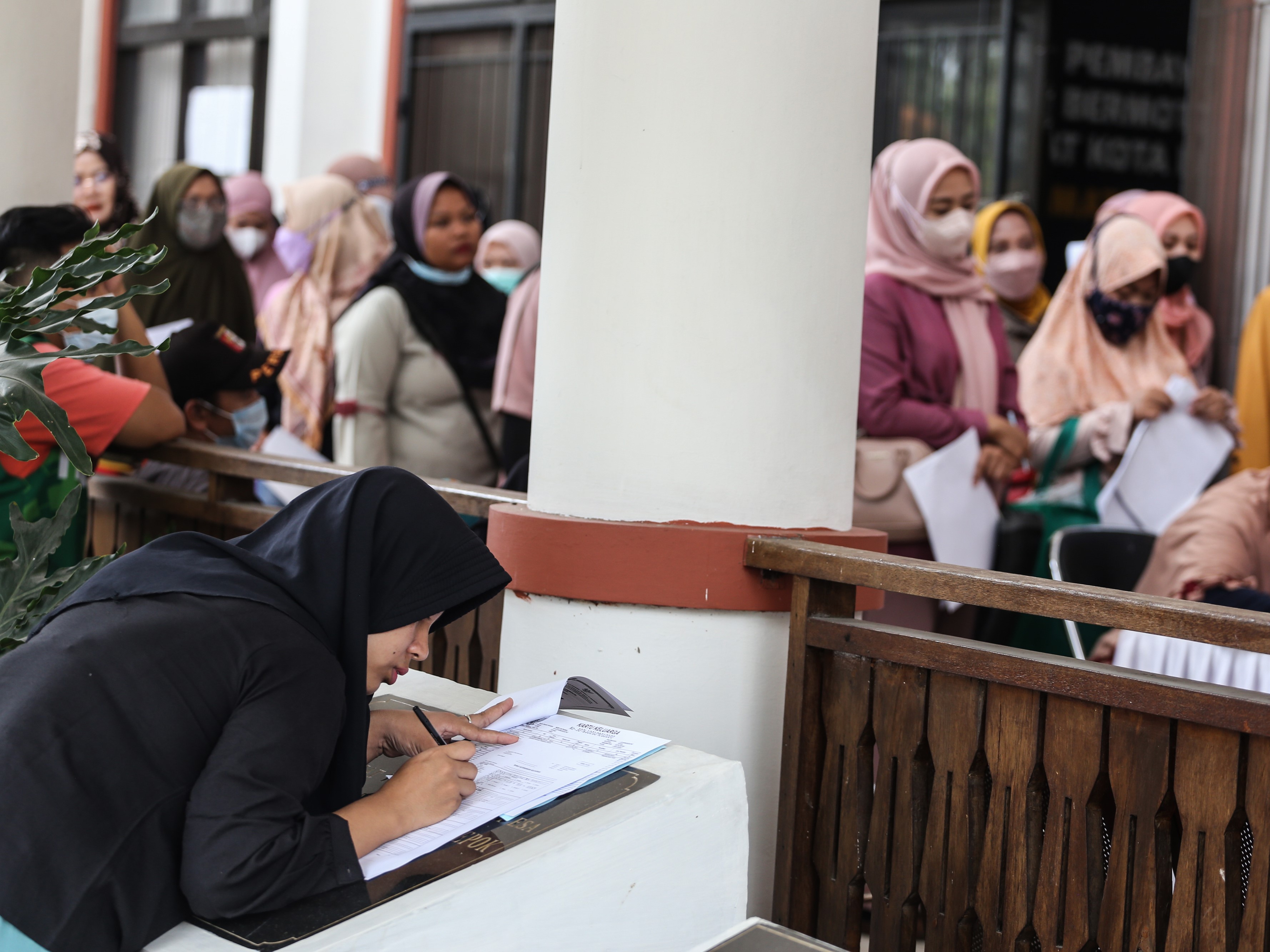 Warga mengisi formulir pendaftaran pembuatan Kartu Identitas Anak (KIA) di Kantor Kecamatan Tapos, Depok, Jawa Barat, Sabtu (22/10/2022). 