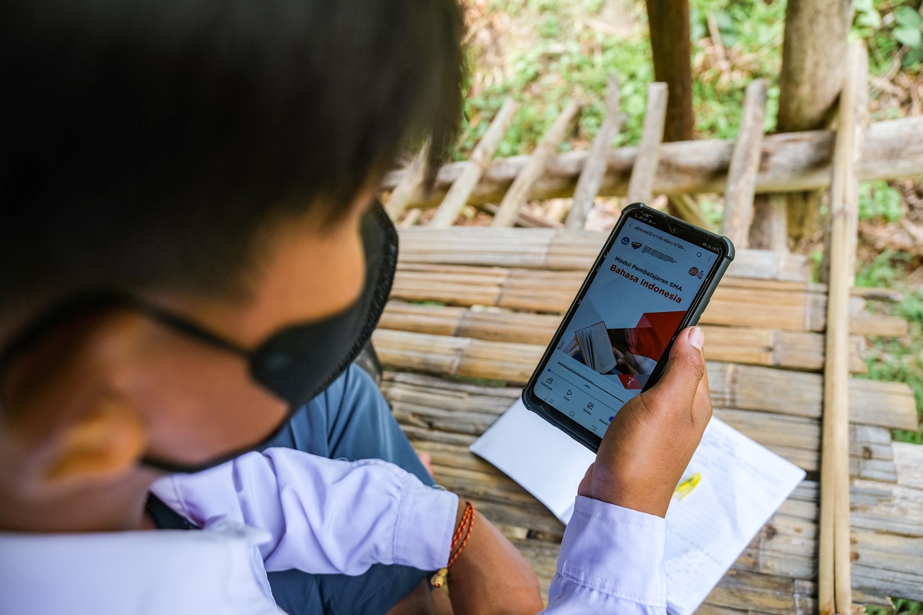 Seorang pelajar menggunakan gawai mereka di salah satu spot sinyal internet yang berada di gubuk Desa Tanampulu, Donggala, Sulteng.