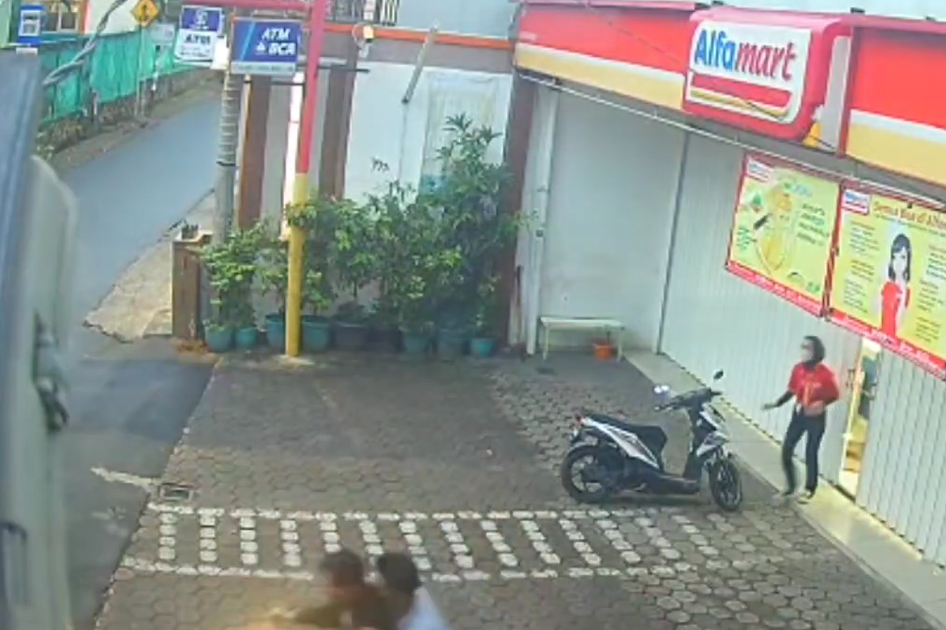 Karyawati tampak keluar dari minimarket meneriaki pencuri yang segera kabur.