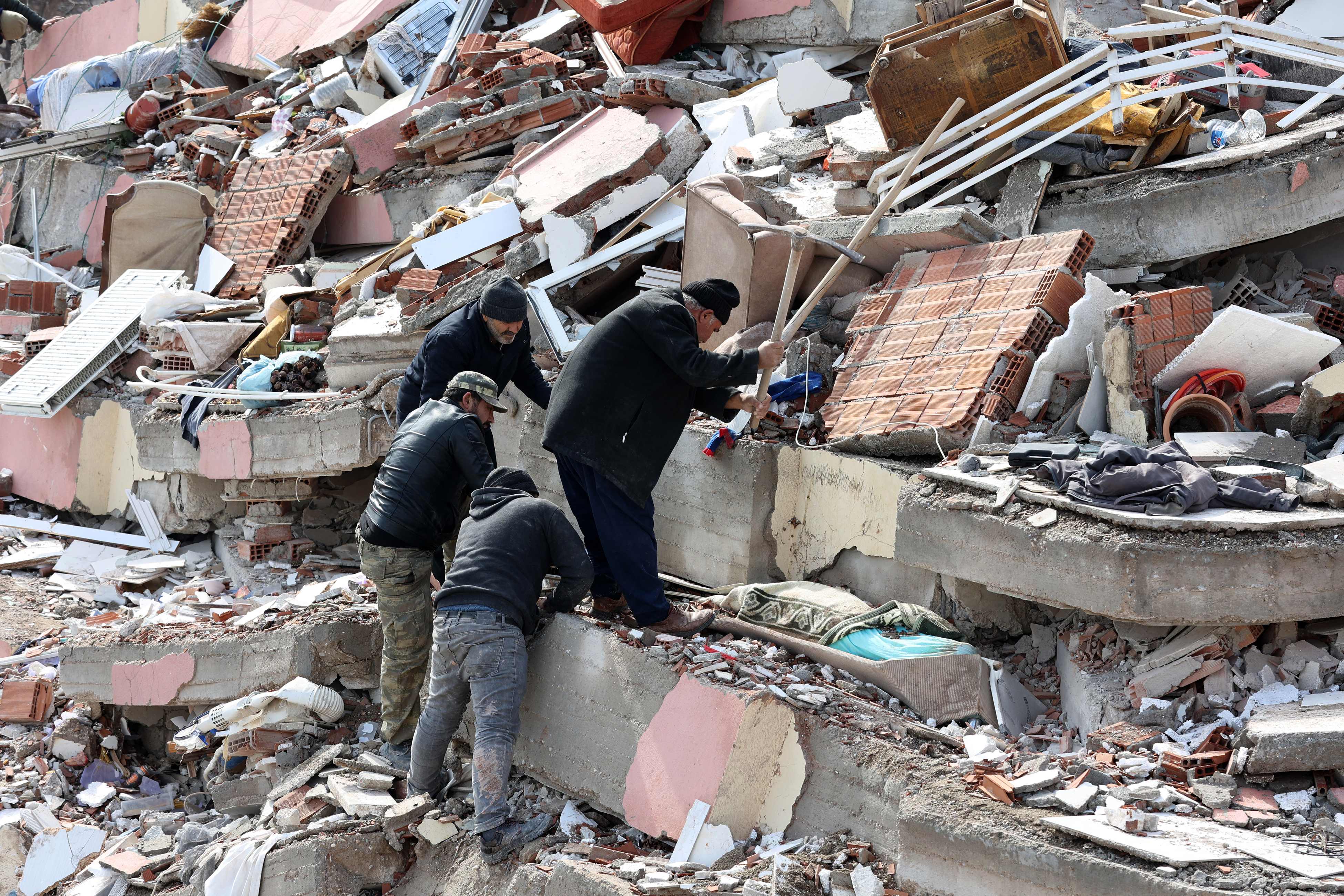 Warga Kahramanmaras, Turki memindahkan puing-puing dari bangunan rumah mereka yang terkena gempa