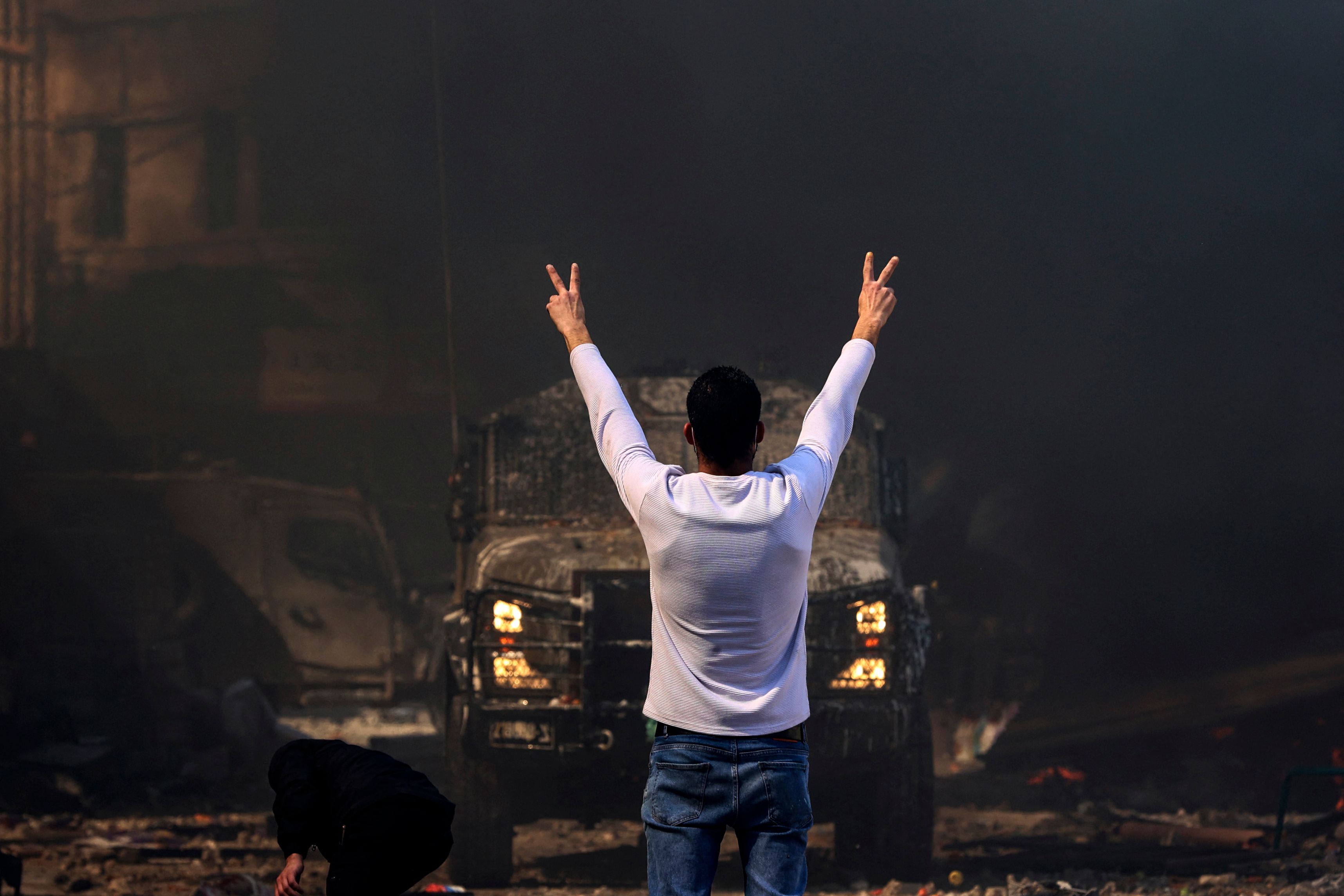 Seorang warga Palestina menghalangi laju kendaraan militer Israel di Nablus, Tepi Barat, Rabu (22/2).