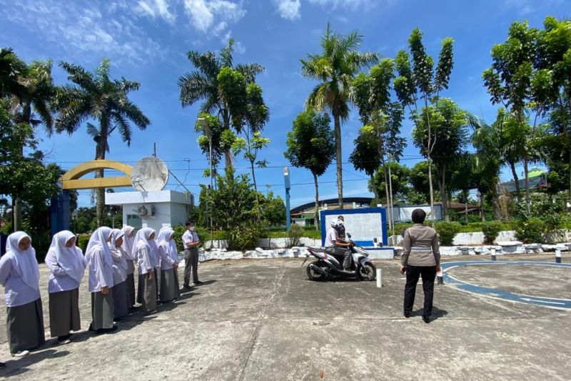  Personil Sat Lantas Polres Agam sedang memberikan materi tentang membawa kendaraan kepada warga yang mengurus pembuatan SIM