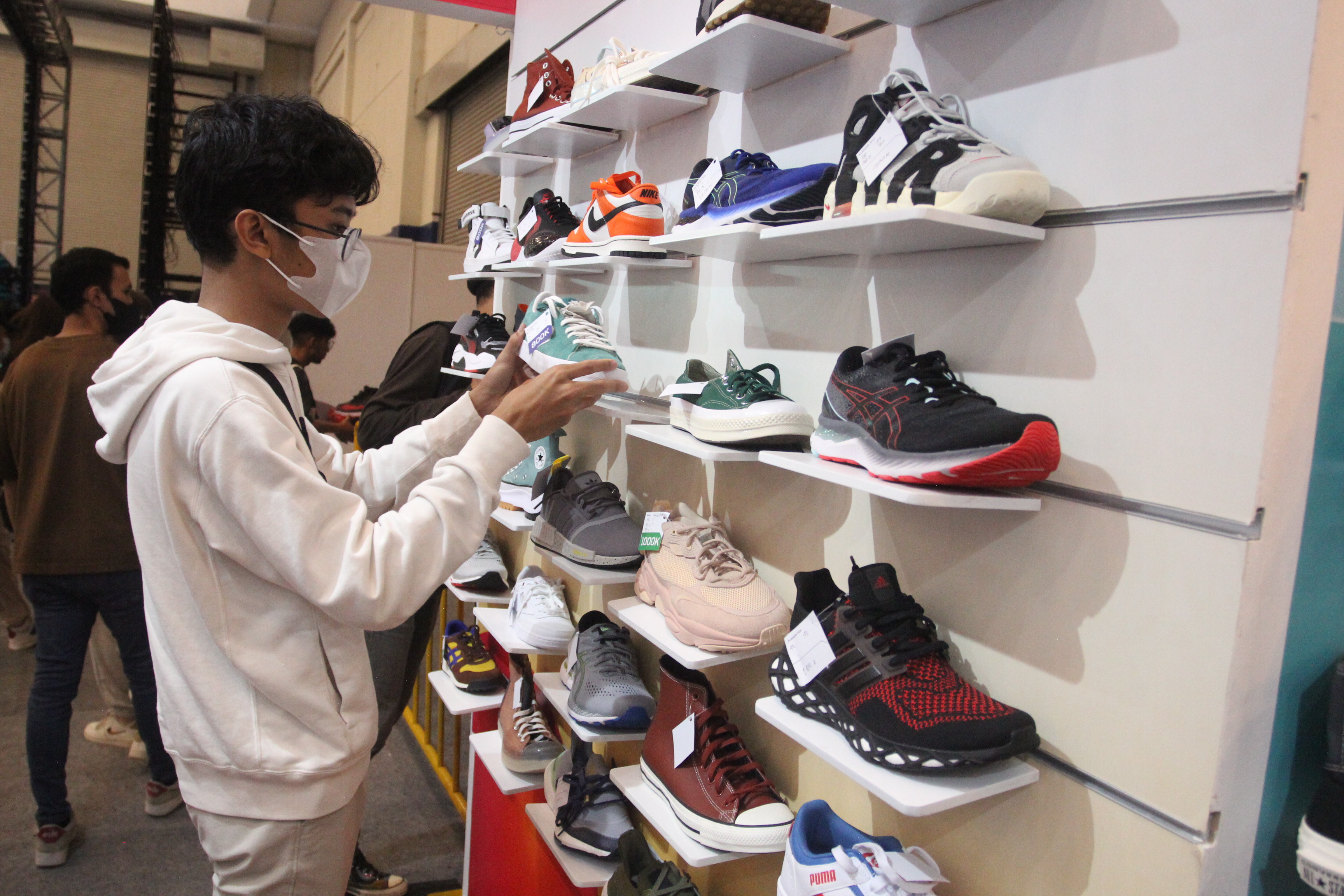 Seorang pengunjung melihat sepatu yang dipajang di Jakarta Sneaker Day (JSD) 2023, Jumat (23/2).