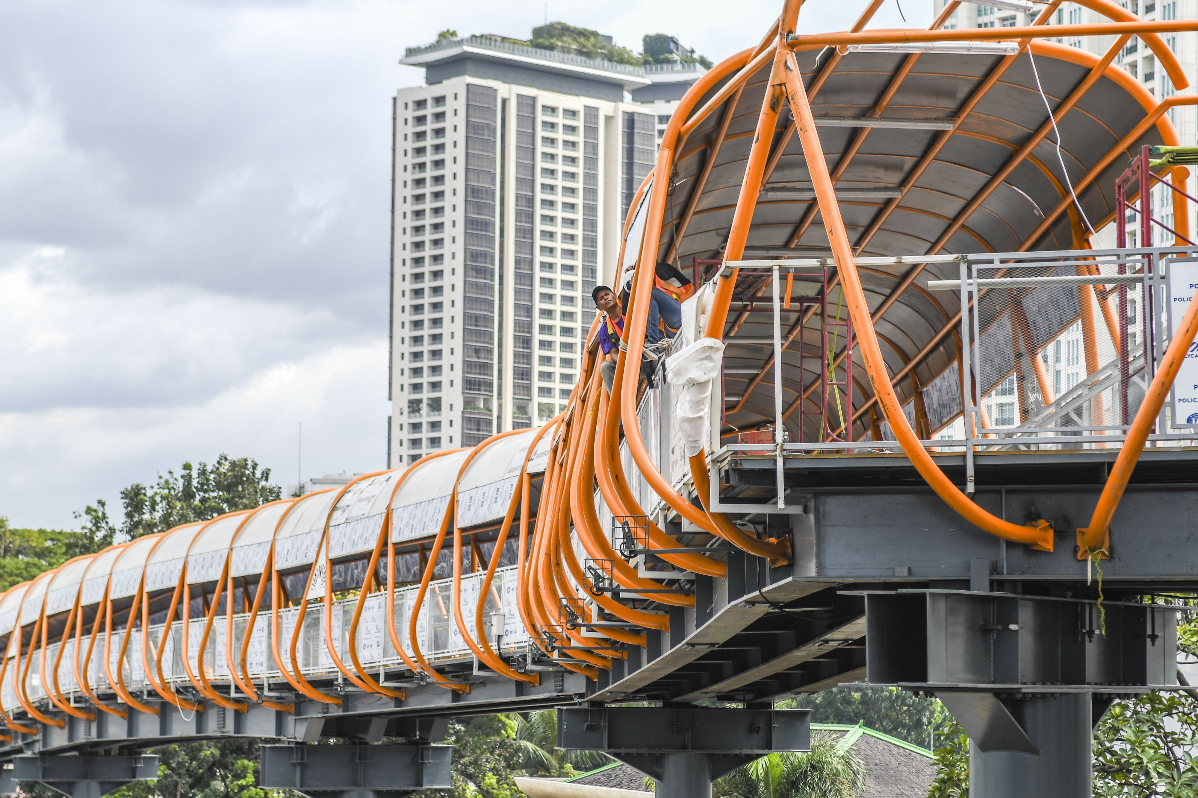 Pekerja menyelesaikan pembangunan jembatan penyeberangan orang (JPO) atau 