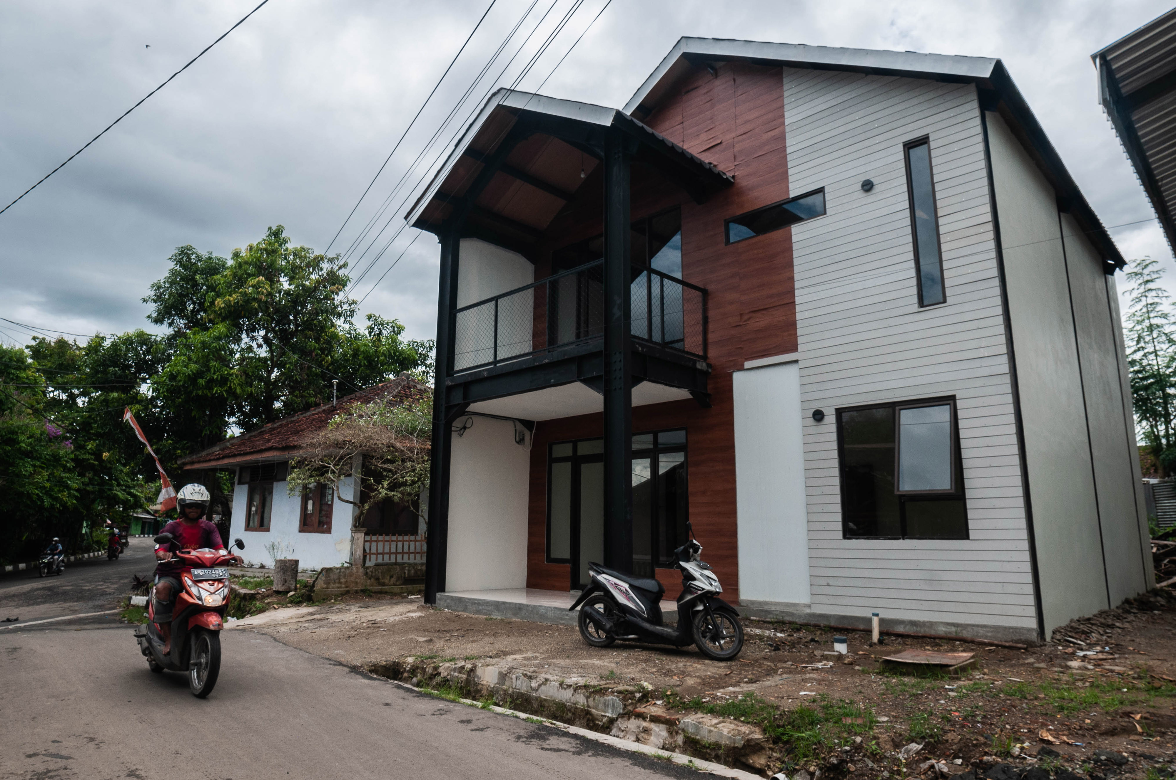 Warga melintas di depan rumah tahan gempa di Rangkasbitung, Lebak, Banten, Jumat (21/1/2022)