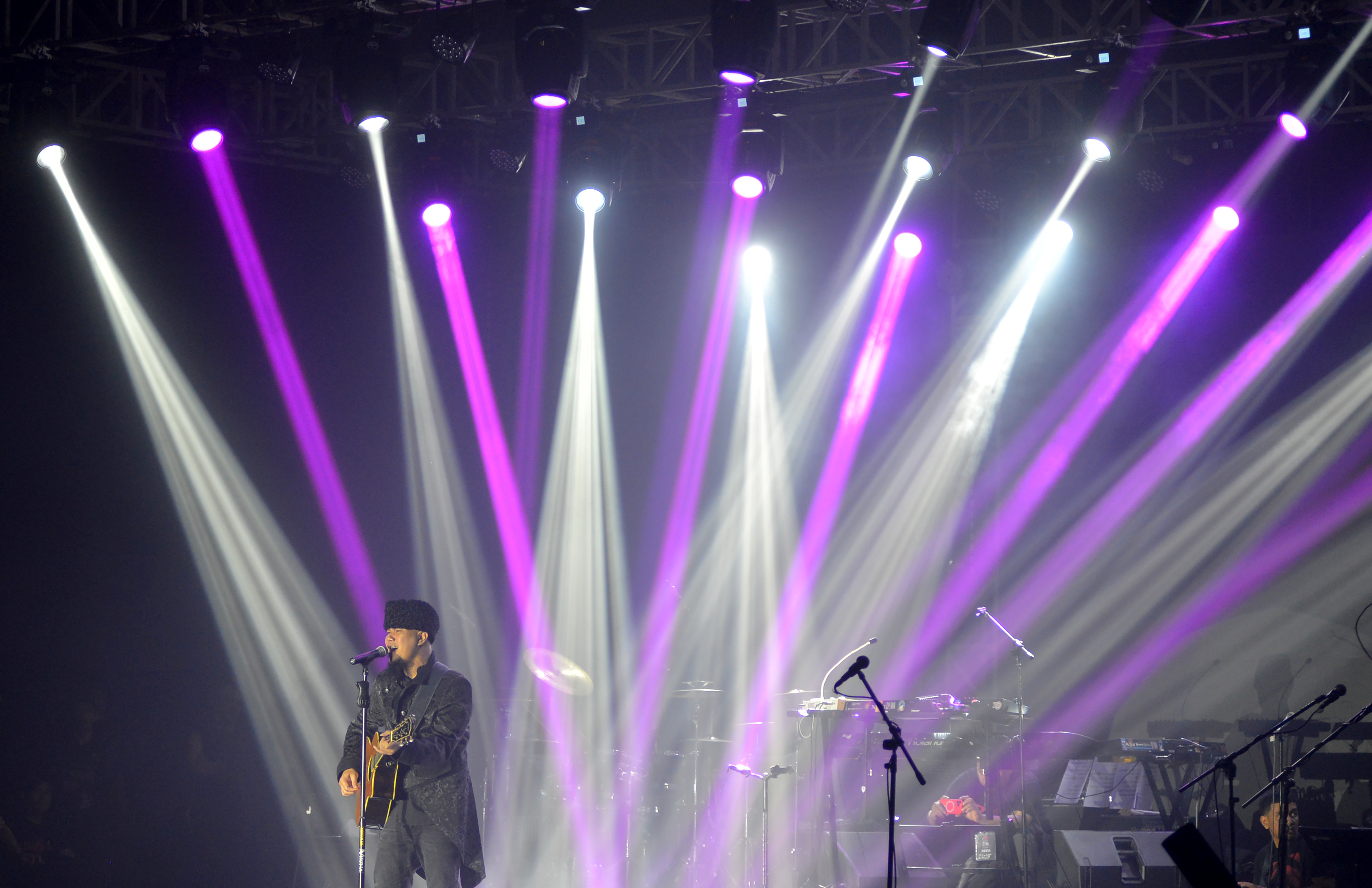 Personel band Dewa 19 Ahmad Dhani saat menyanyikan lagu dalam sebuah konser.