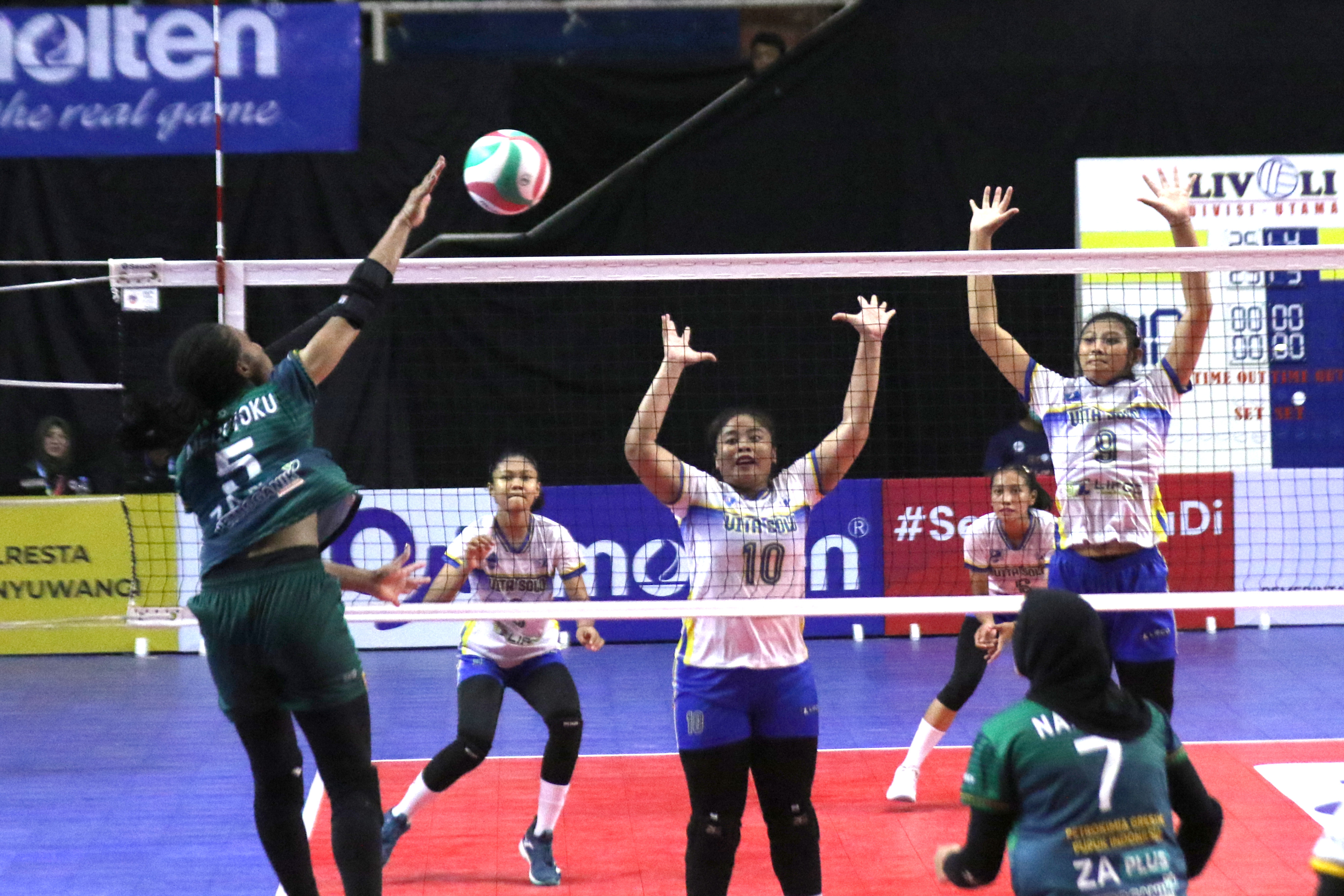 Pemain  Petrokimia Gresik Pupuk Indonesia Mediol Stiovanny (kiri)  berupaya melepaskan smash.