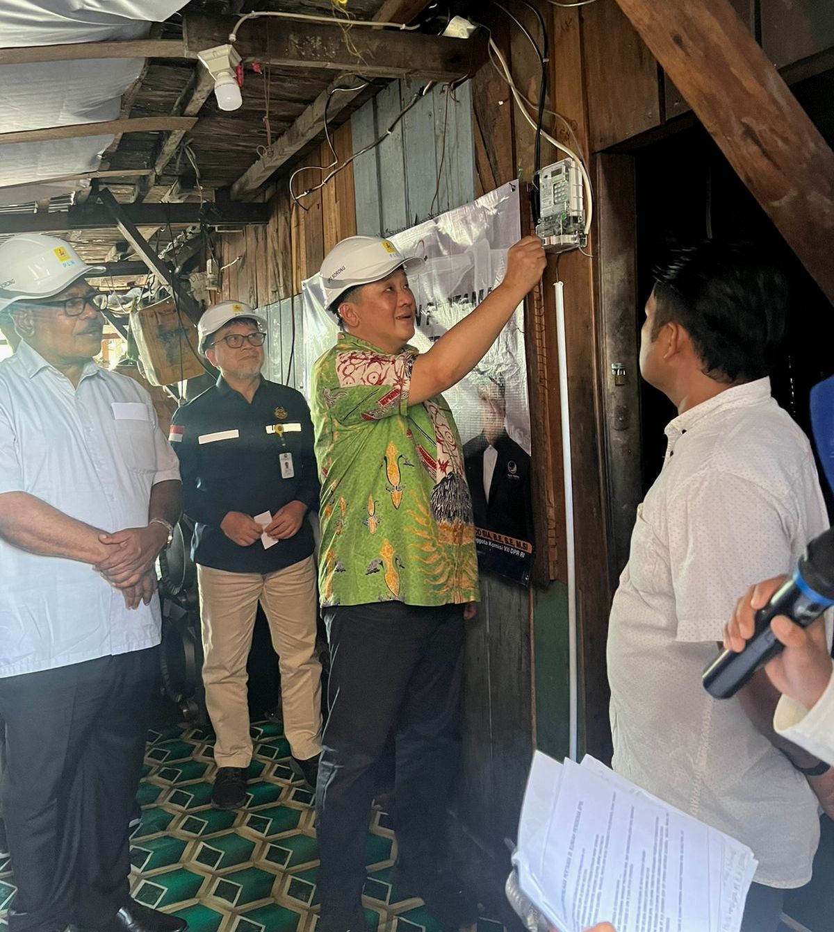 Rico Sia memencet saklar lampu di salah satu rumah warga.