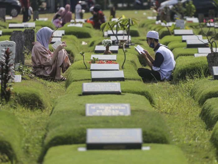 Sejumlah warga berdoa saat ziarah kubur di permakaman covid-19, Srengseng Sawah, Jakarta, Senin.