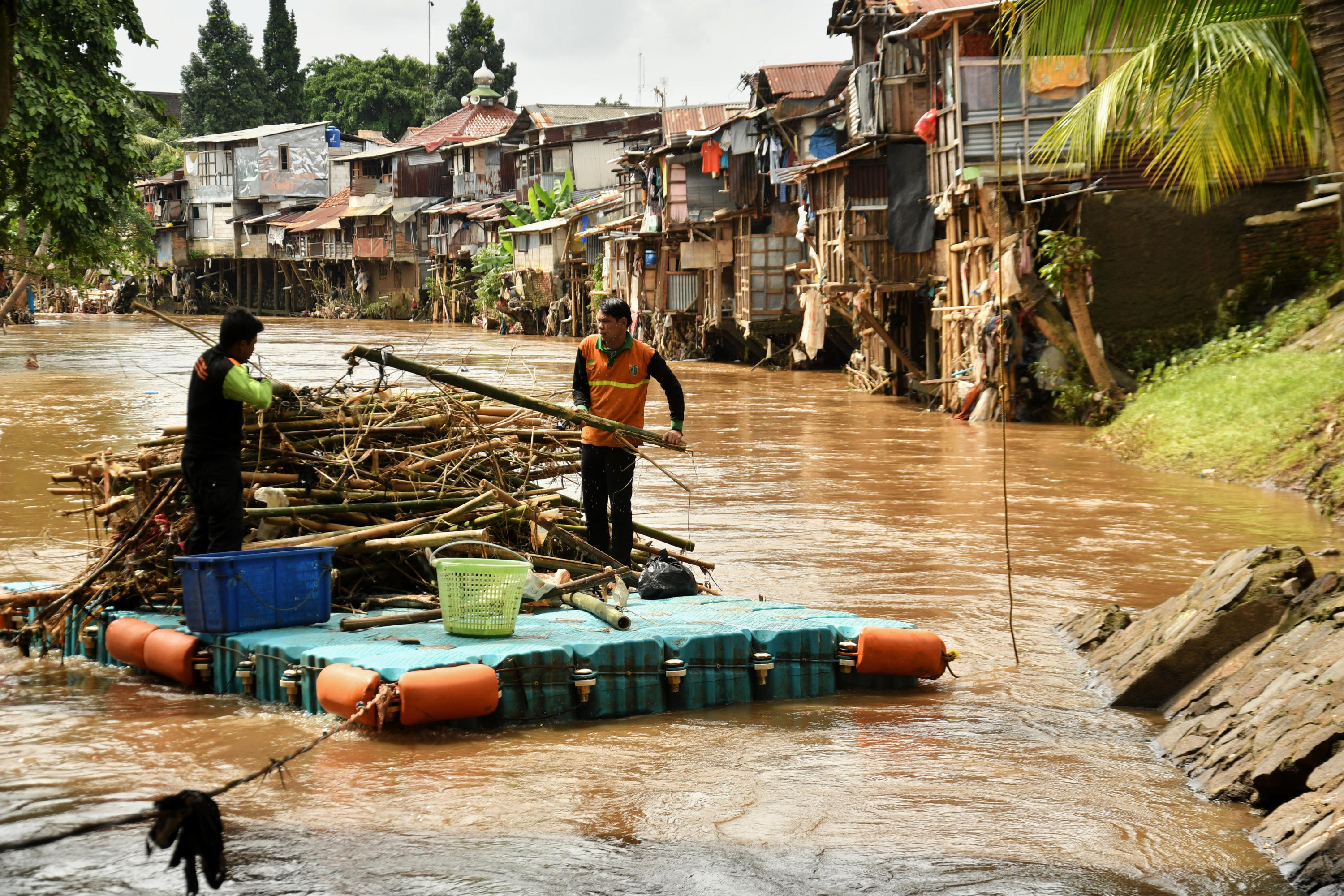 Potret petugas membersihkan sampah di Kali Ciliwung.