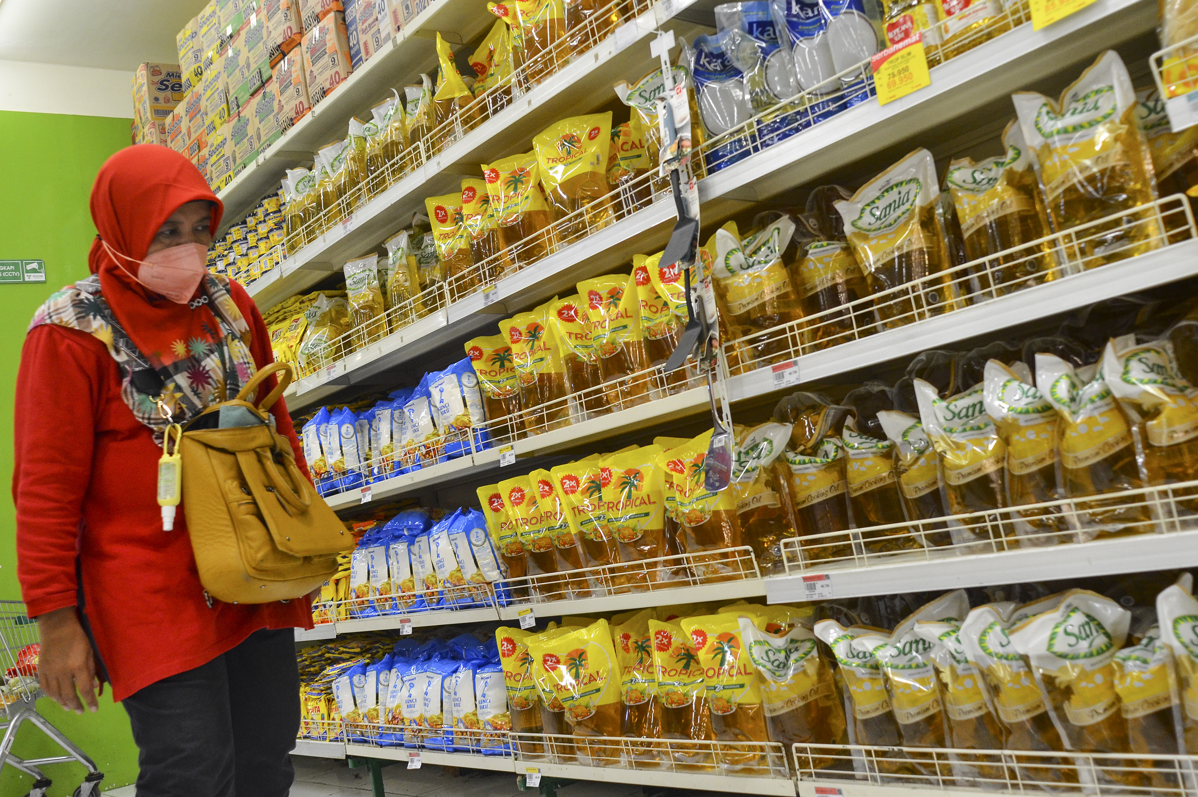 Pengunjung membeli minyak goreng kemasan di pusat perbelanjaan.