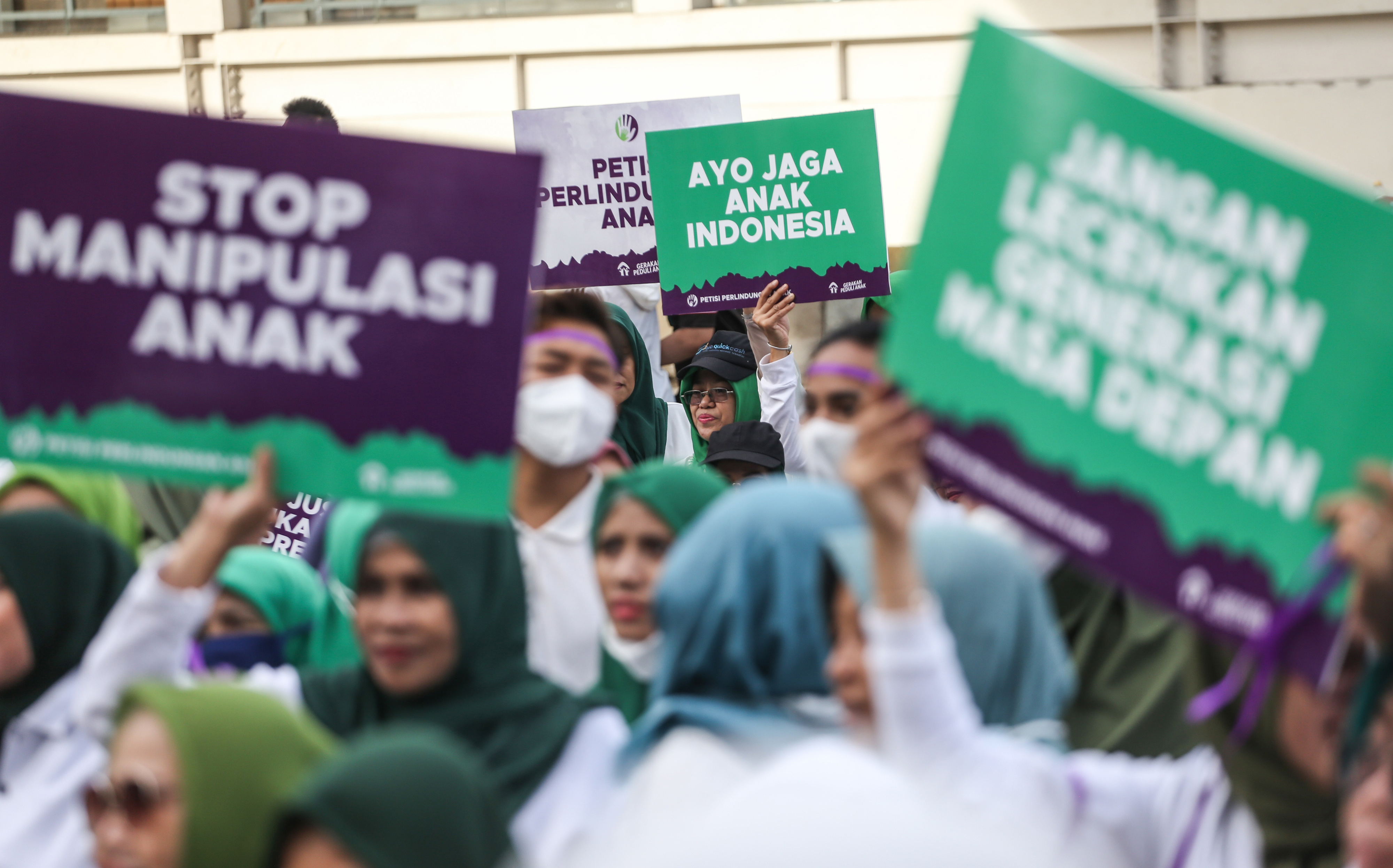 Sejumlah relawan membawa poster saat penandatanganan petisi perlindungan anak di Sarinah, Jakarta, Minggu (8/1/2023). 
