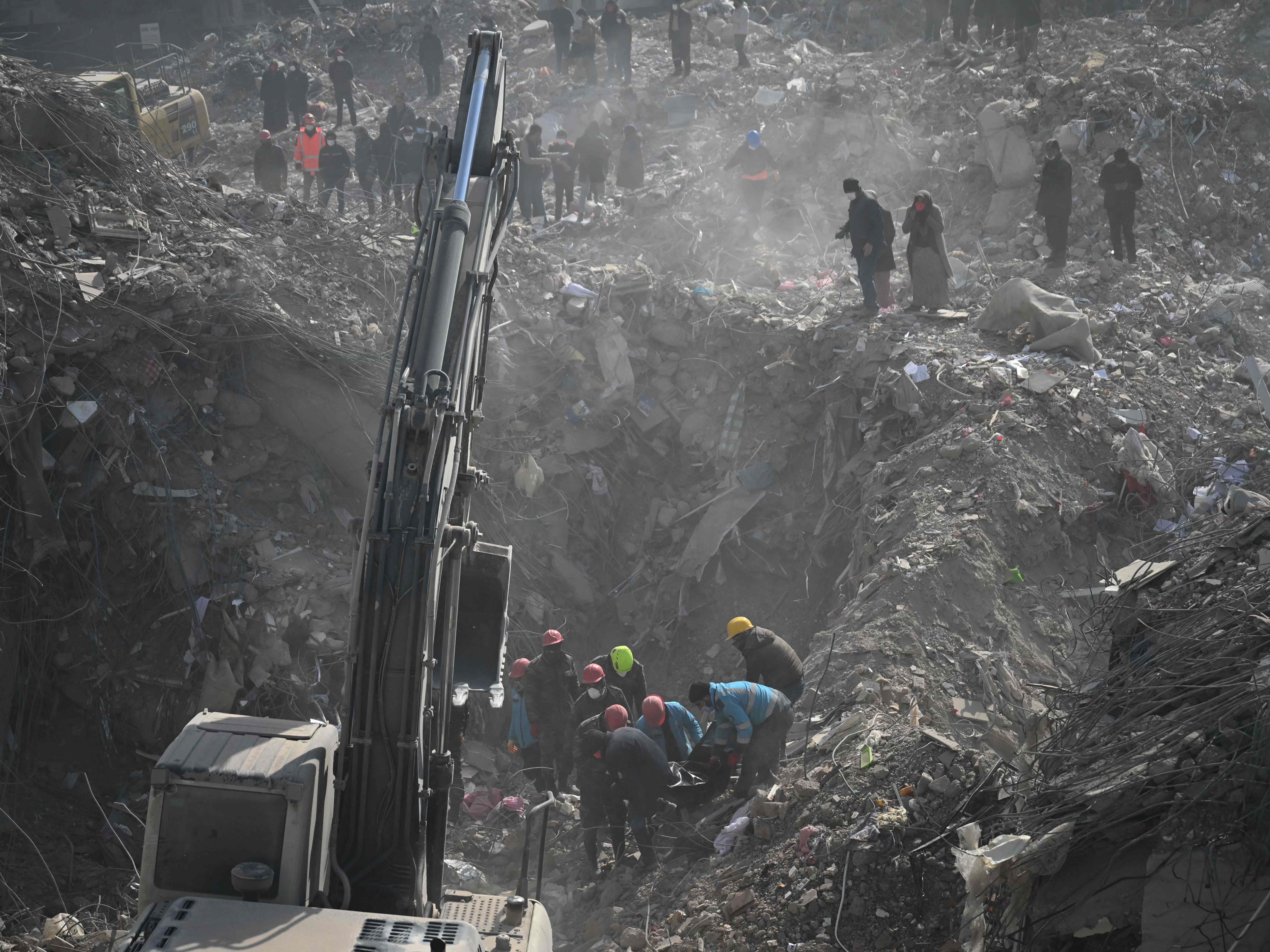 Tim pencari dan penyelamat mengevakuasi mayat yang ditemukan di puing-puing bangunan yang runtuh di Kahramanmaras pada 14 Februari 2023.