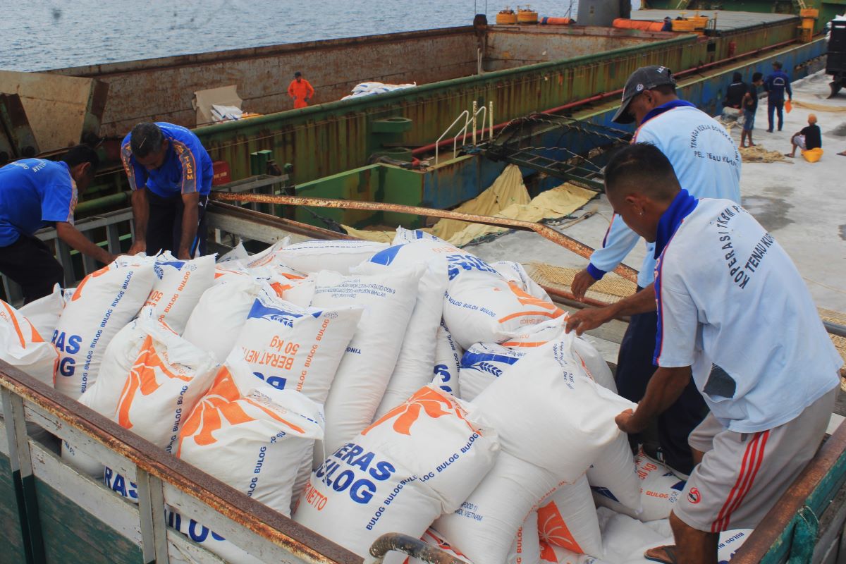 Petugas membongkar beras impor