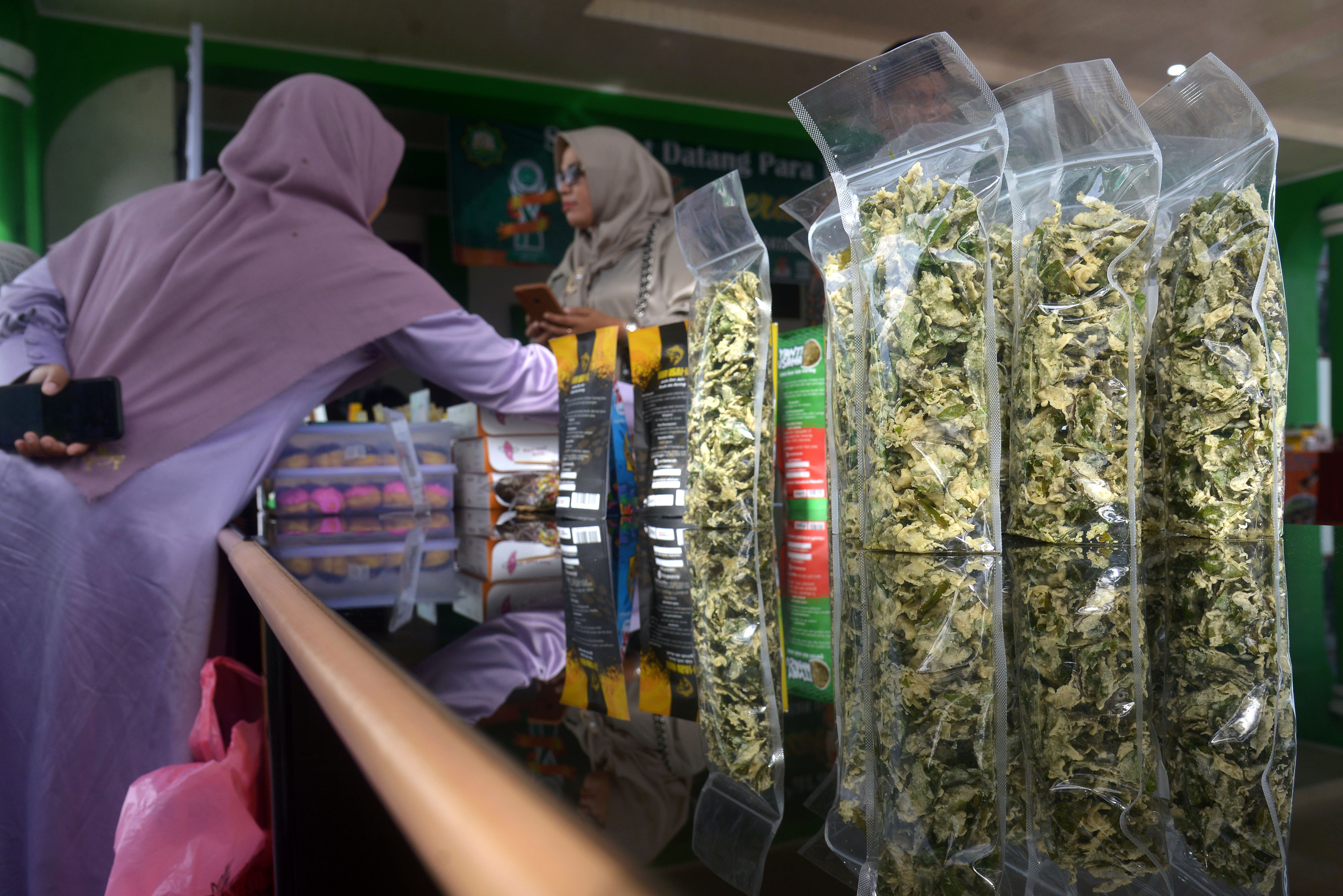 Pelaku usaha menata produk saat pameran produk halal di Majelis Permusyawaratan Ulama (MPU) Aceh, Kabupaten Aceh Besar, Senin (5/12/2022). 