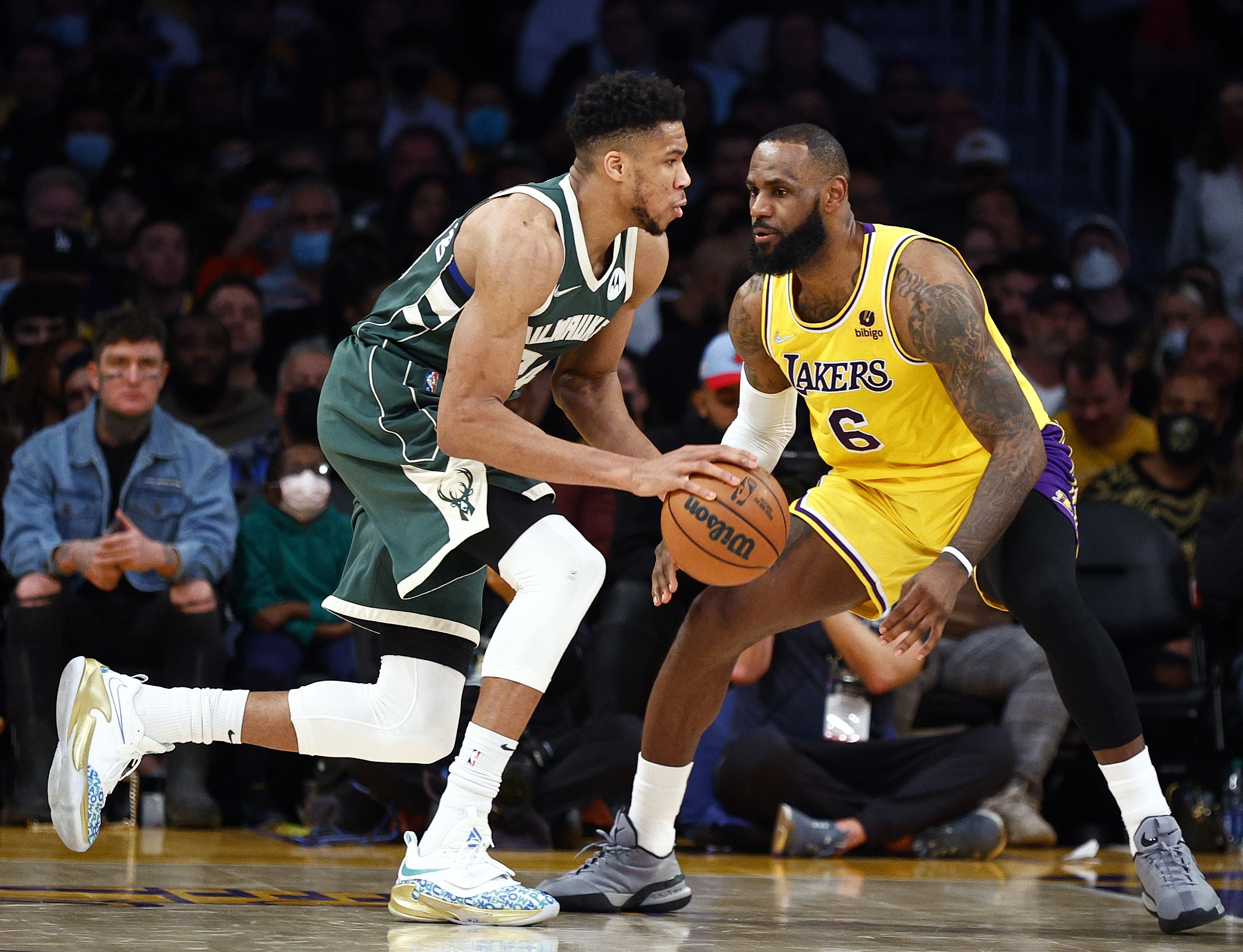 Pebasket Milwaukee Bucks Giannis Antetokounmpo (kiri) berhadapan dengan pebasket Los Angeles Lakers LeBron James.