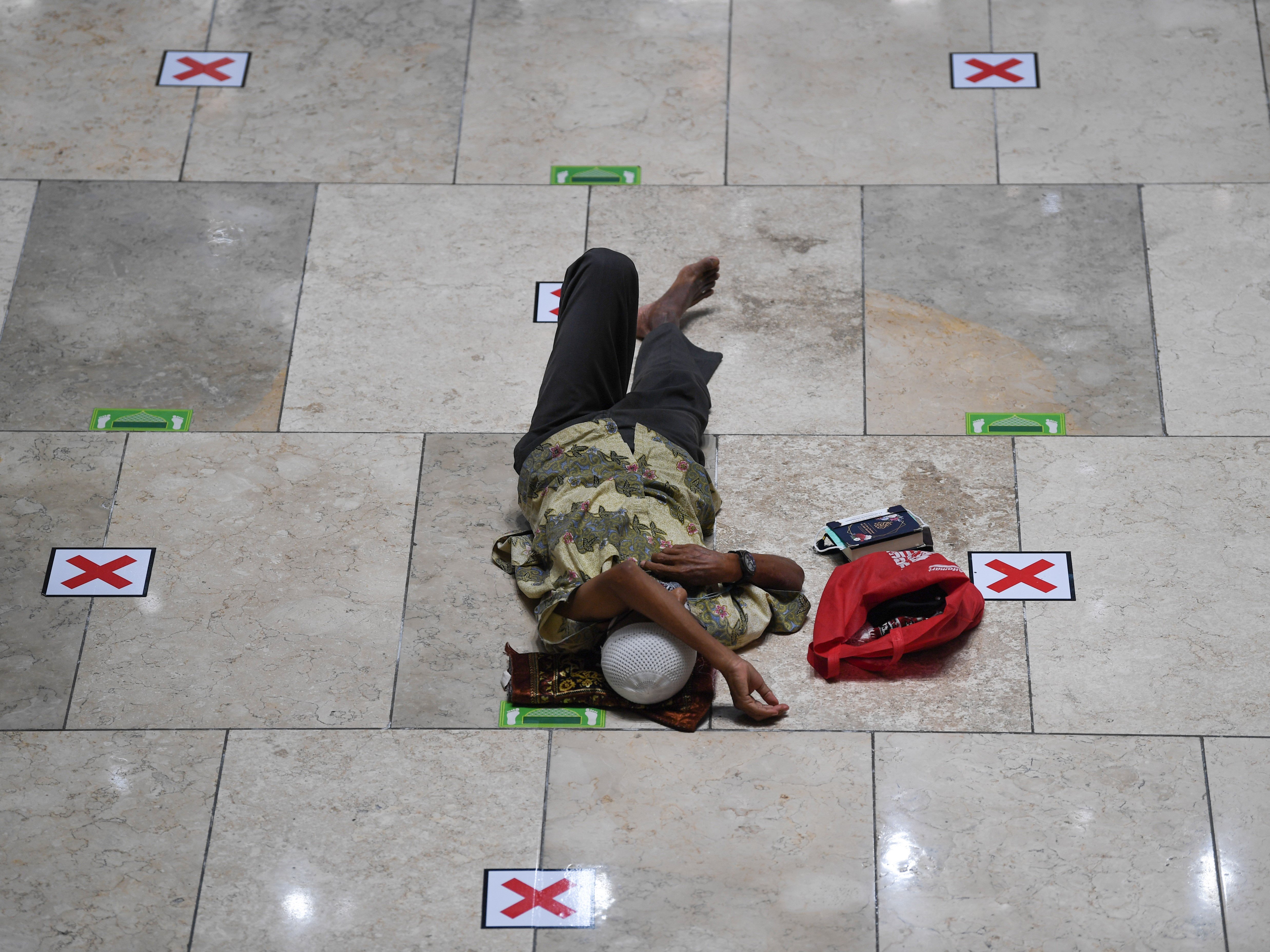 Seseorang tidur saat menunggu salat ashar di Masjid Istiqlal, Jakarta.