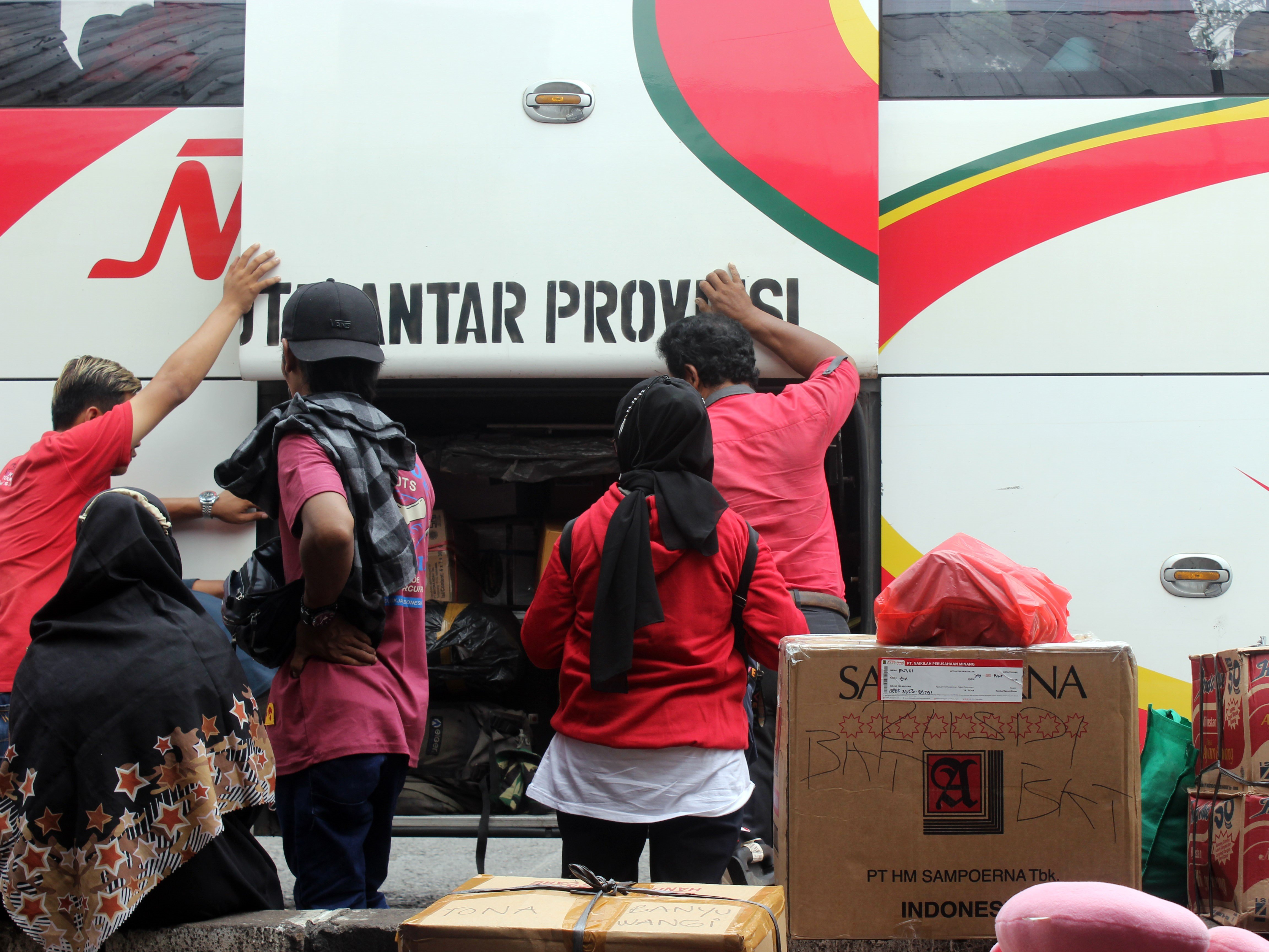 Calon penumpang memasukkan barang bawaan ke bagasi bus di Terminal Bus Kalideres, Jakarta, Kamis (7/7/2022). 