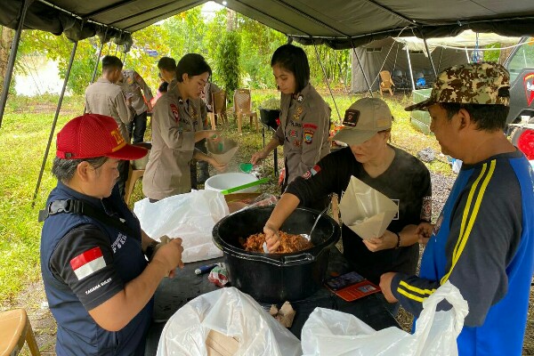 Sejumlah anggota Brimob Polda Sulawesi Utara menyiapkan makanan untuk pengungsi banjir di Manado