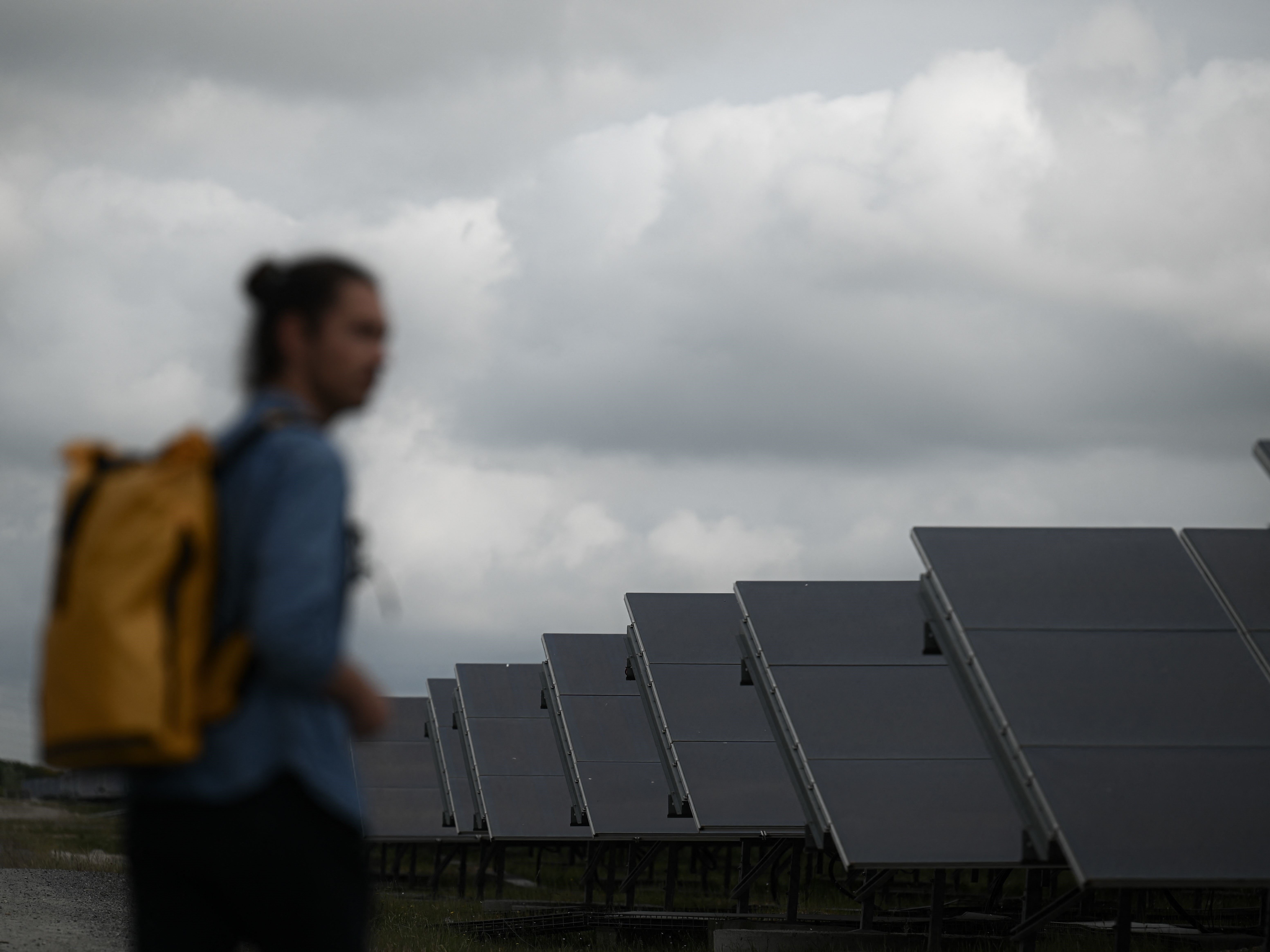 Seorang pria melihat panel surya Labarde di Bordeaux barat daya Prancis pada 12 Mei 2022. 