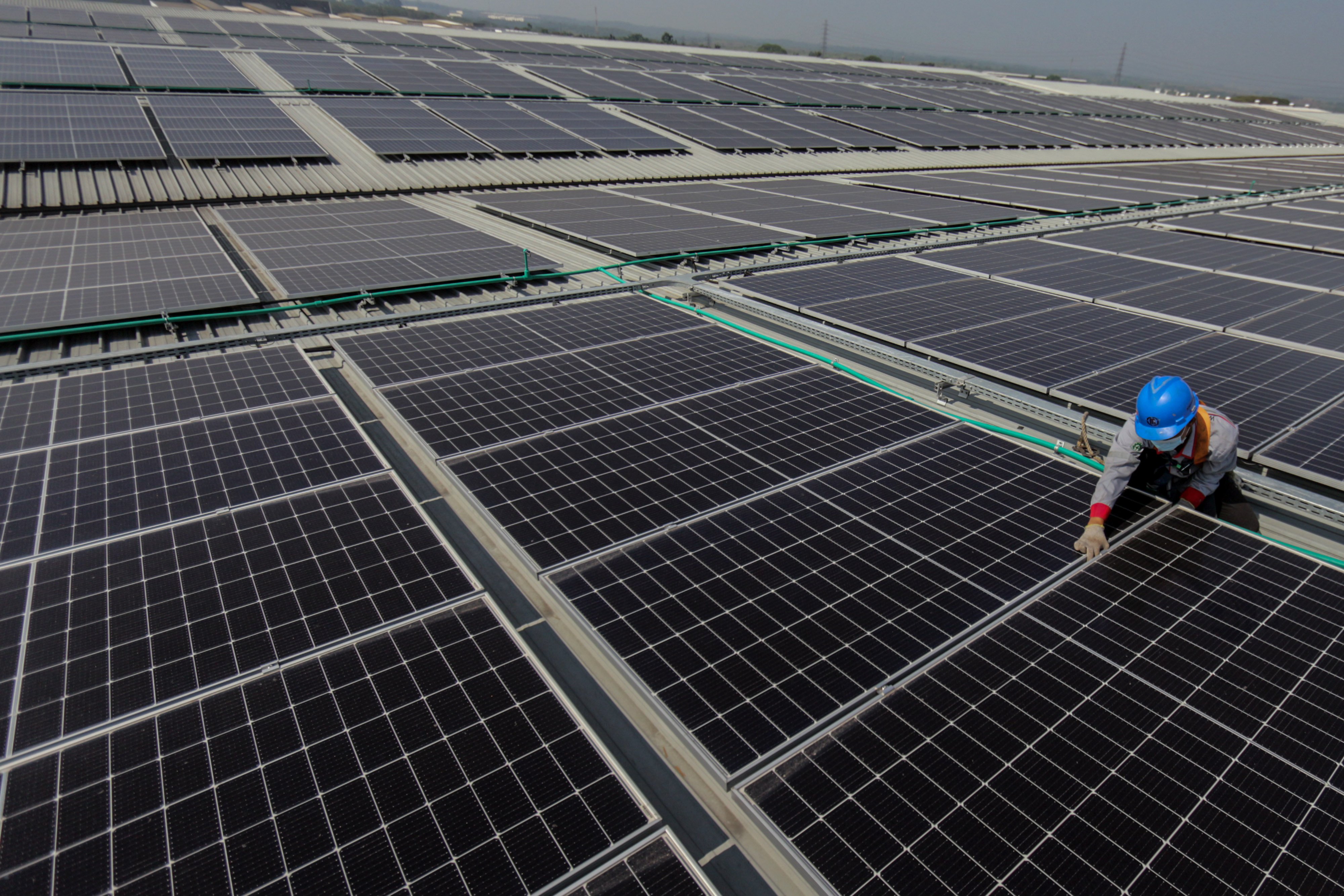 Potret pekerja mengecek fasilitas PLTS.