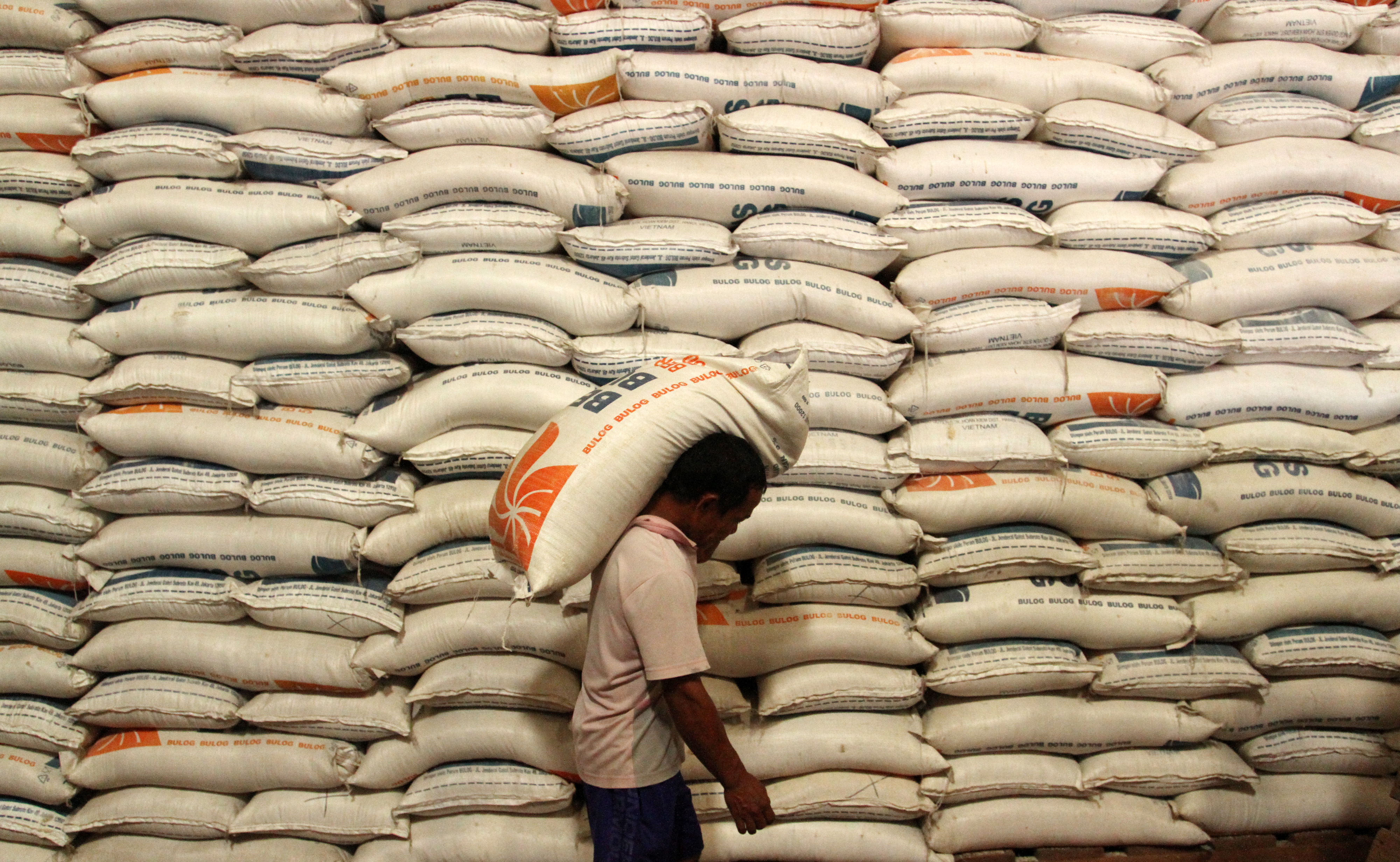 Potret pekerja mengangkut beras di gudang milik Perum Bulog.