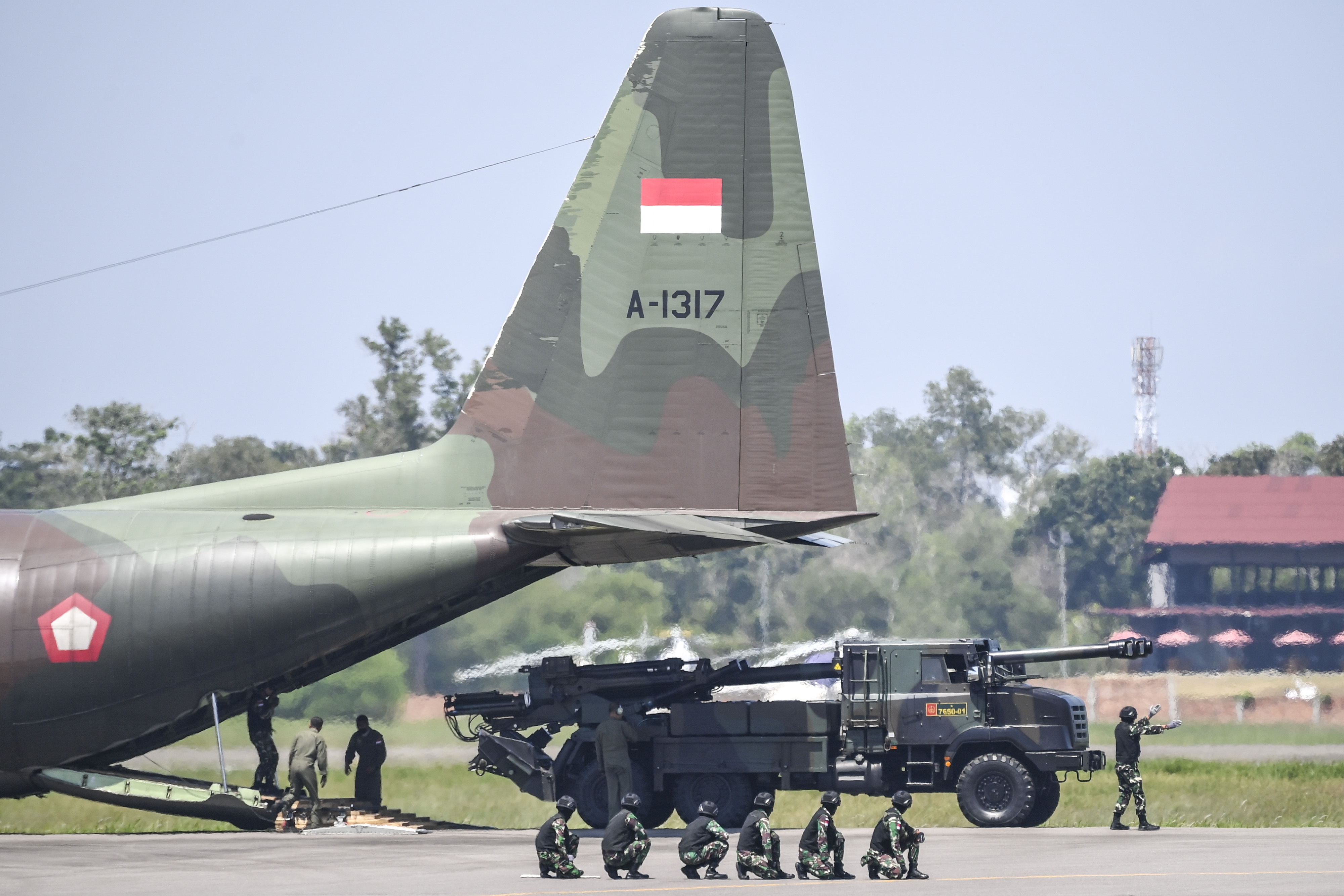 Sebuah kendaraan tempur keluar dari pesawat Hercules milik TNI AU.