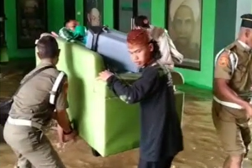 Anggota PC NU mengevakuasi barang.